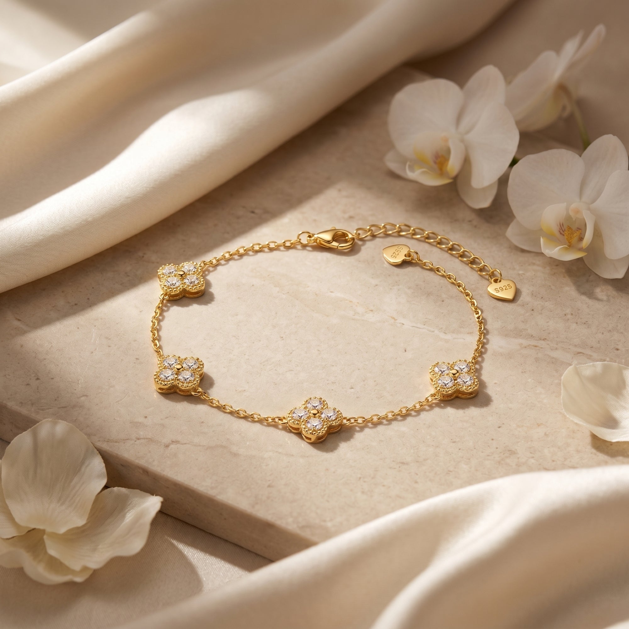 Gold vermeil clover bracelet featuring lab-grown moissanite stones on a neutral stone surface.