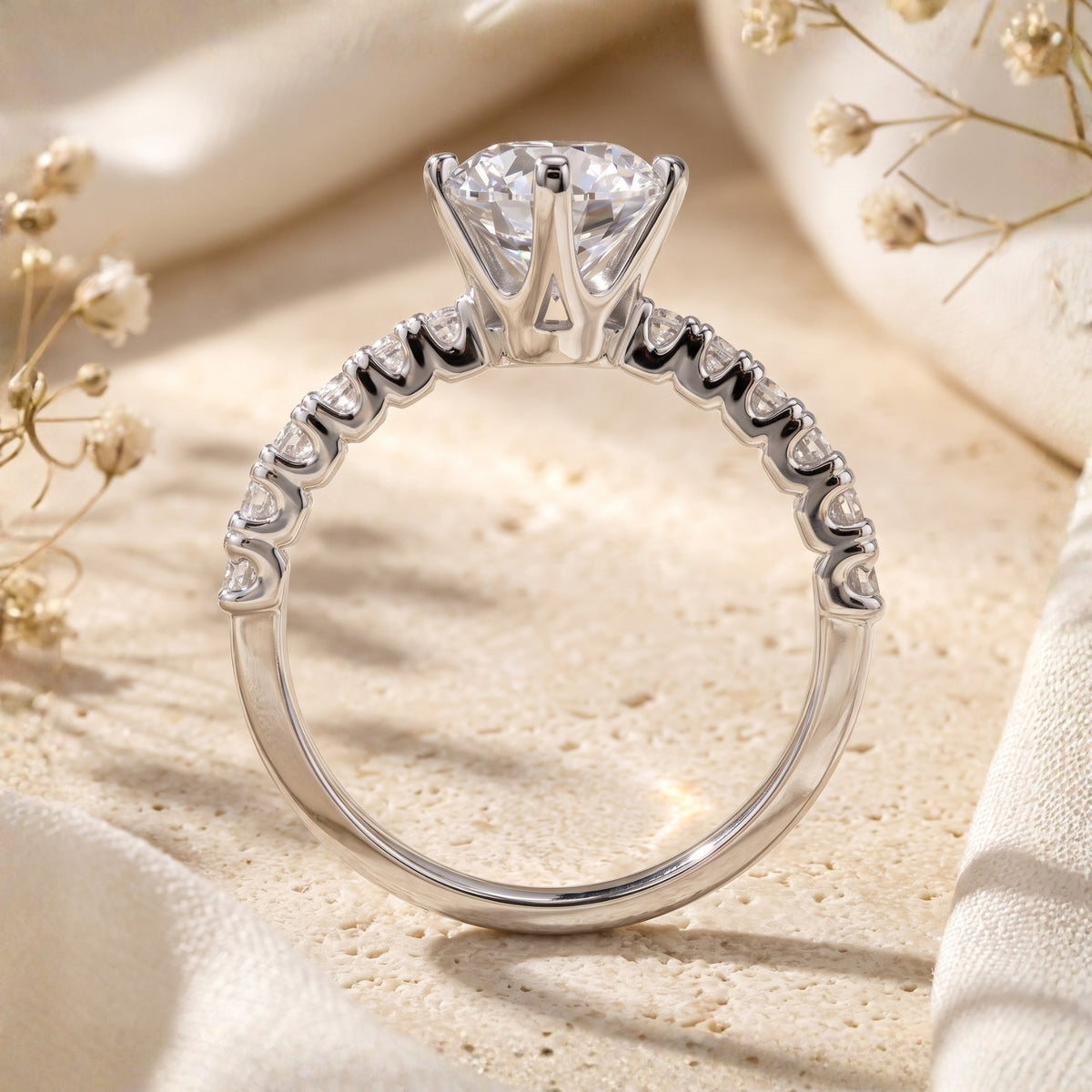 Rear view of a silver solitaire ring showing the elevated center setting and pavé stones along the upper band.
