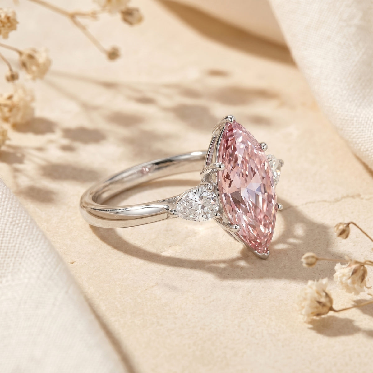 Angled view of the marquise pink moissanite silver ring highlighting the prong setting and side stones.