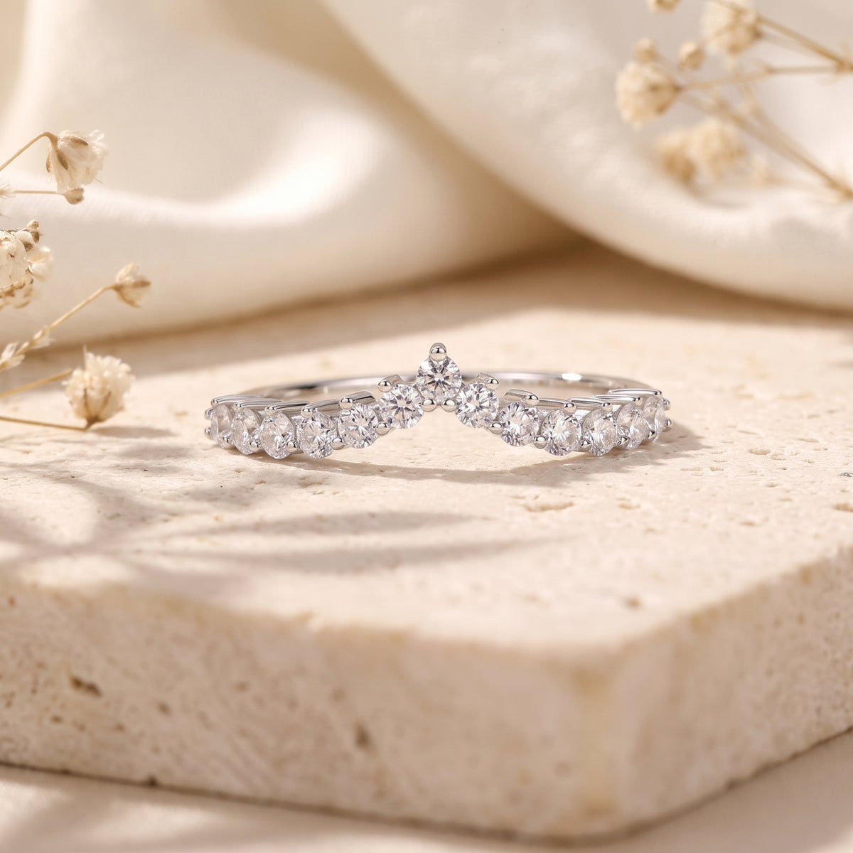 Close-up of a silver chevron ring featuring round-cut cubic zirconia stones.