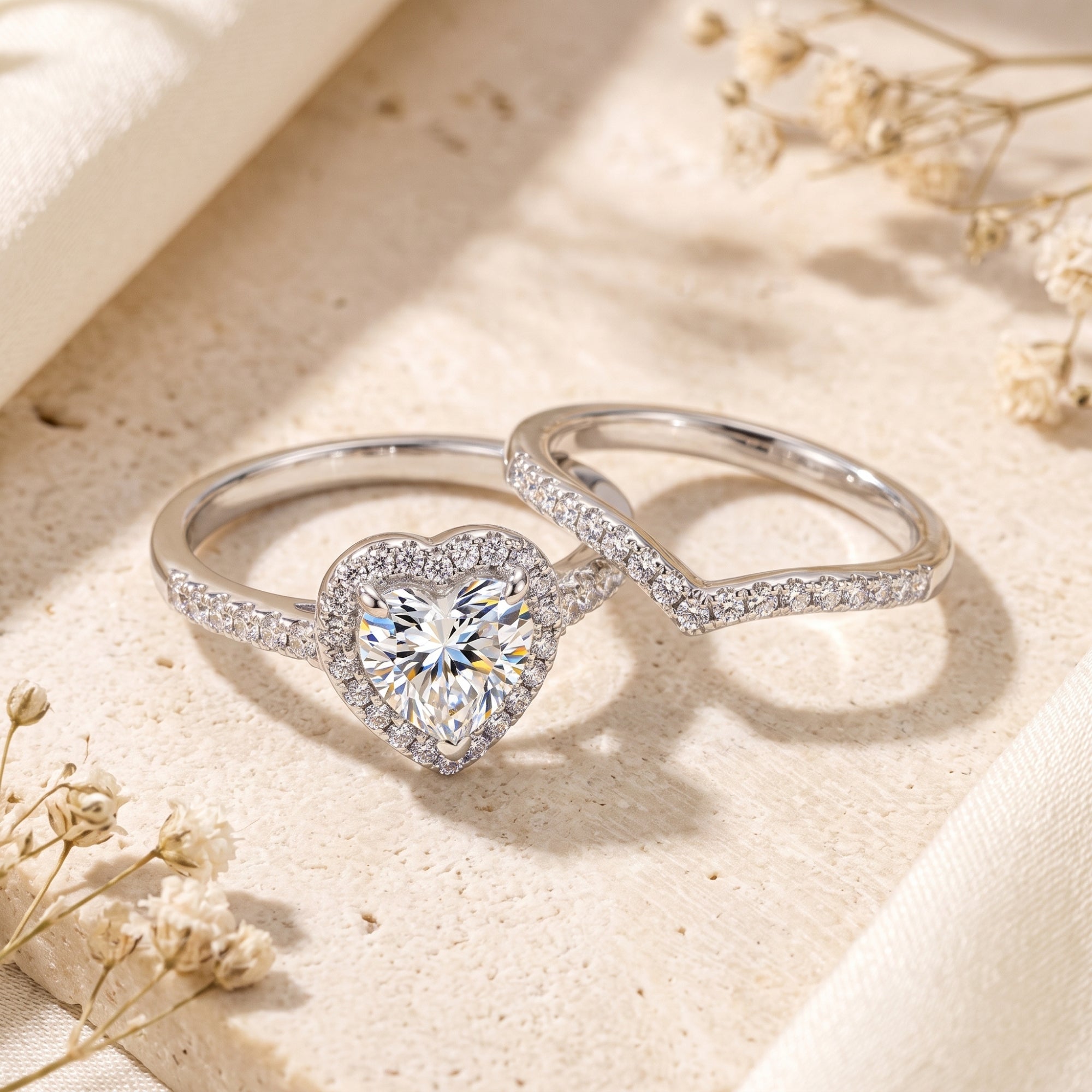 Detail view of silver heart halo ring and chevron band with simulated diamonds.
