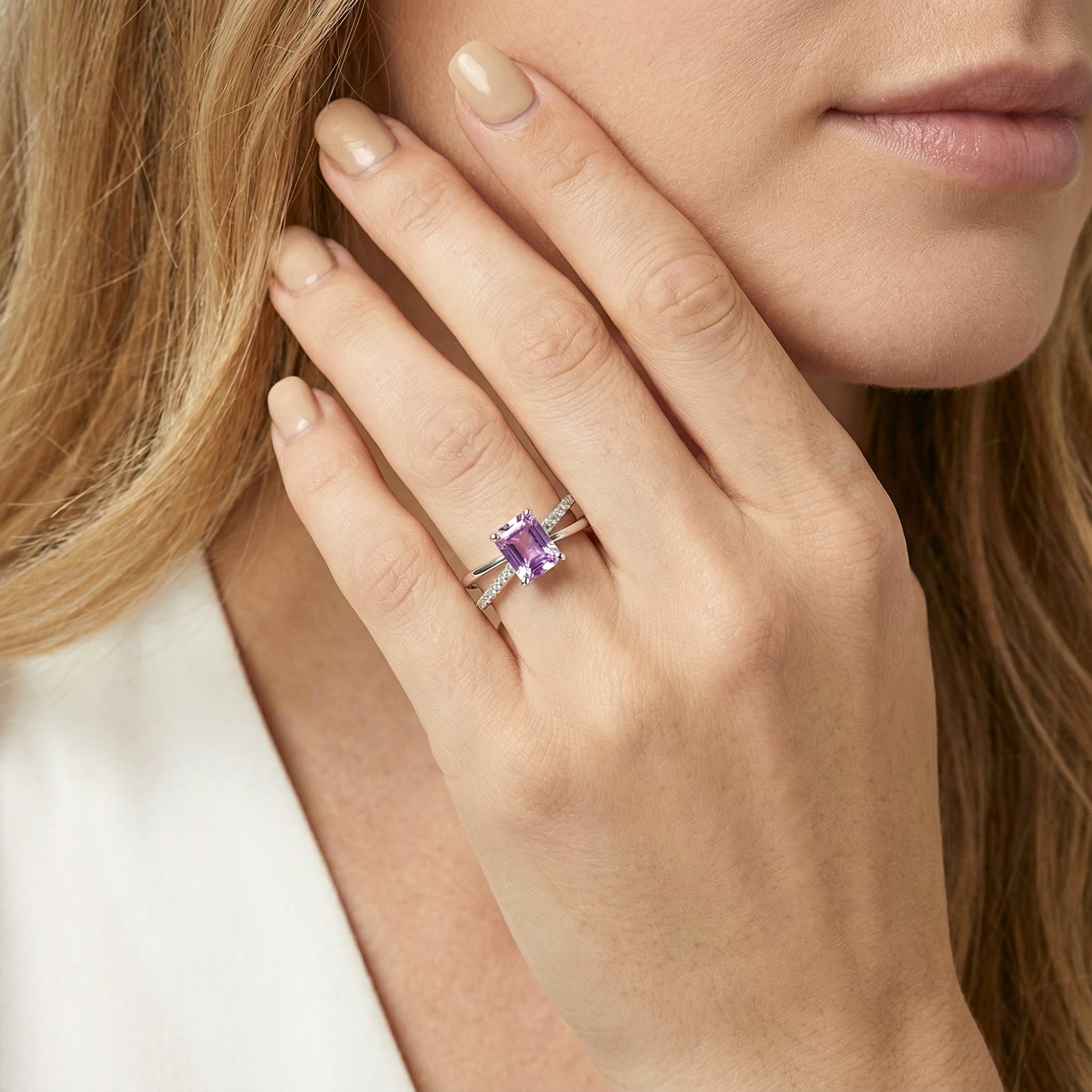 Model wearing the emerald-cut simulated amethyst Evanthe ring in S925 sterling silver on her ring finger.
