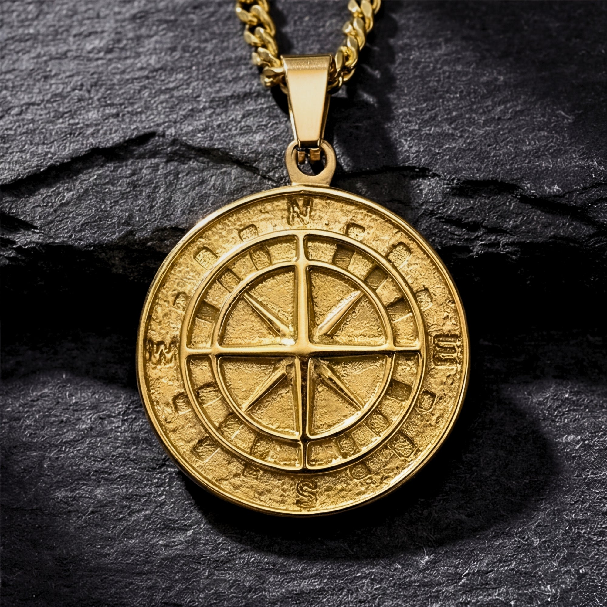 Close-up detail of the gold stainless steel Voyager compass pendant showing the textured face and cardinal points.