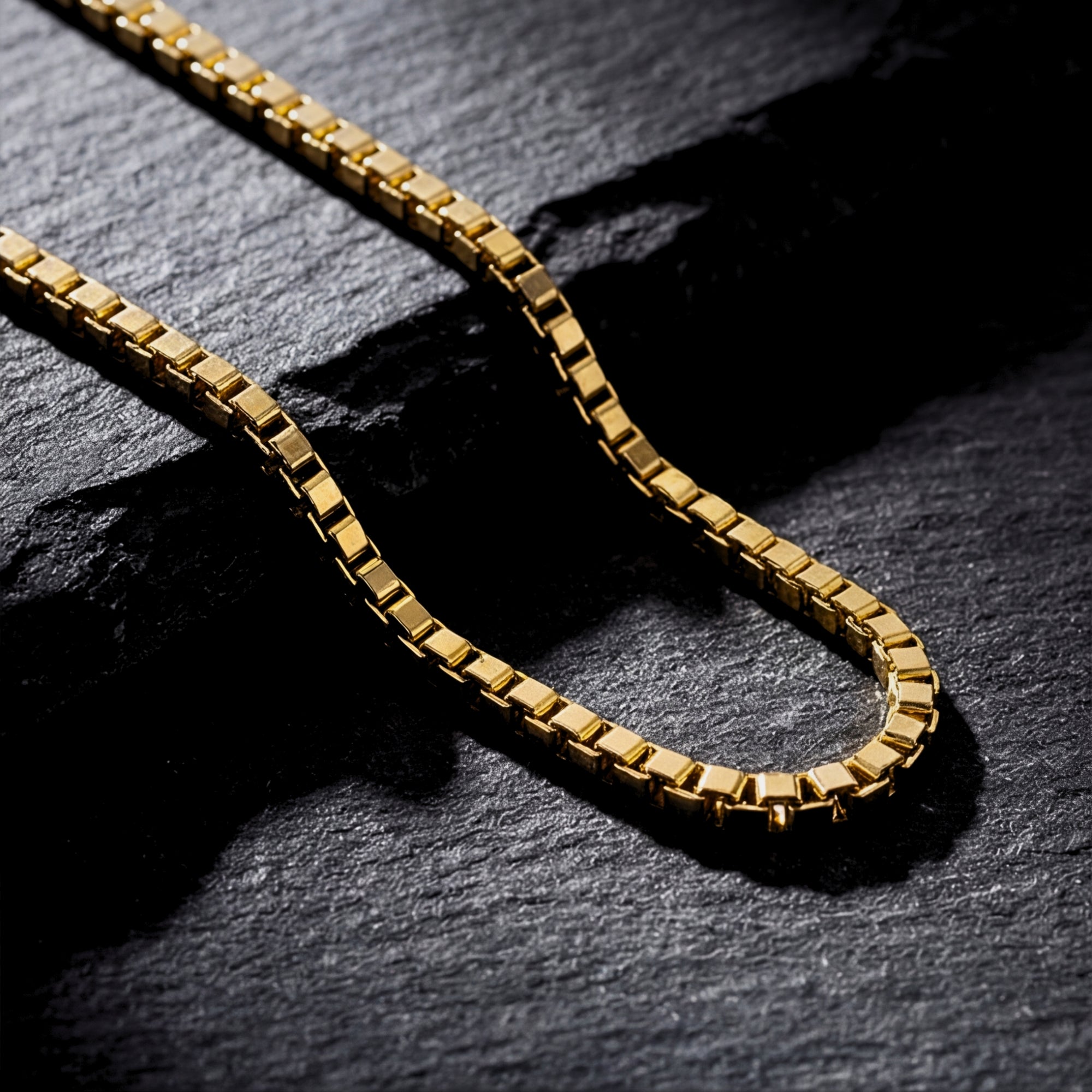 Close-up macro view of the square links on the gold Boxed In chain, highlighting the 18k gold finish.