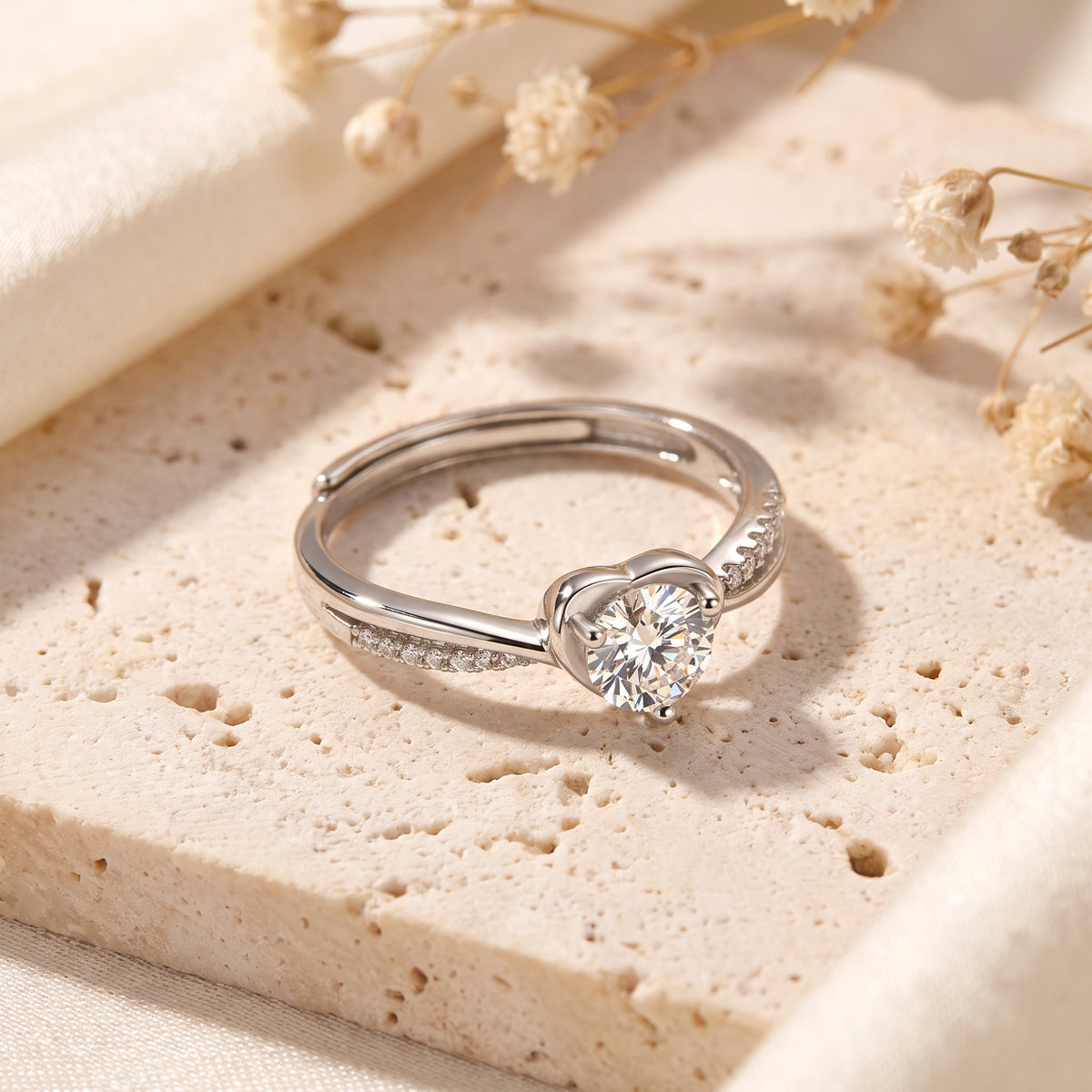 Macro view of the sterling silver heart-shaped basket and shimmering accent stones on the bypass band.
