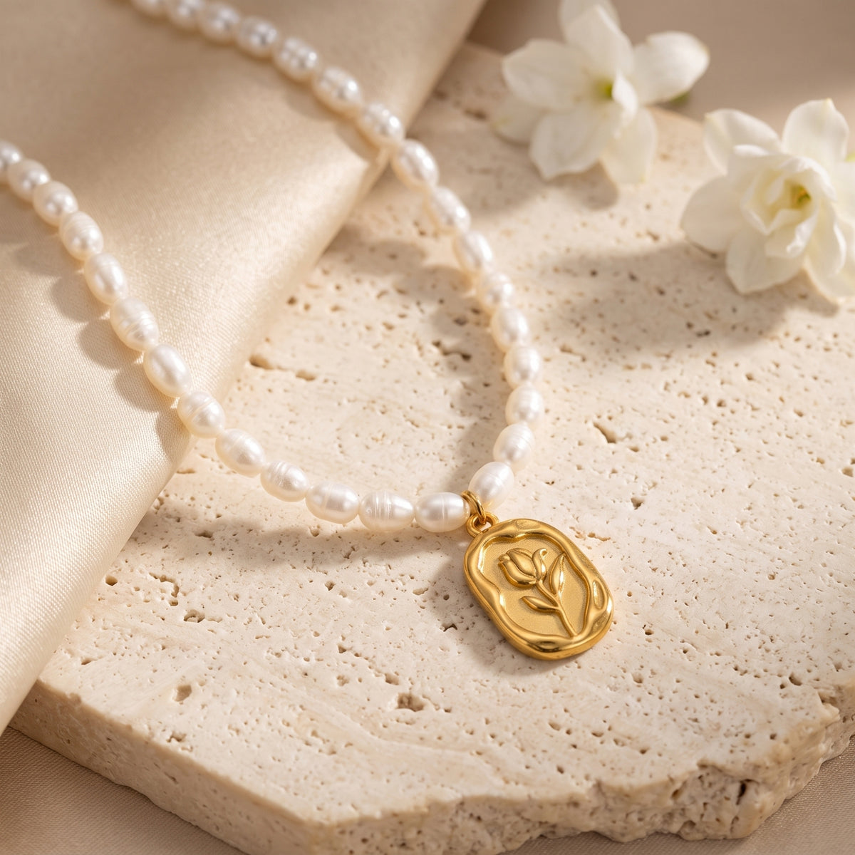 Close-up detail of the sculpted gold rose pendant on the Rosalinde pearl necklace.