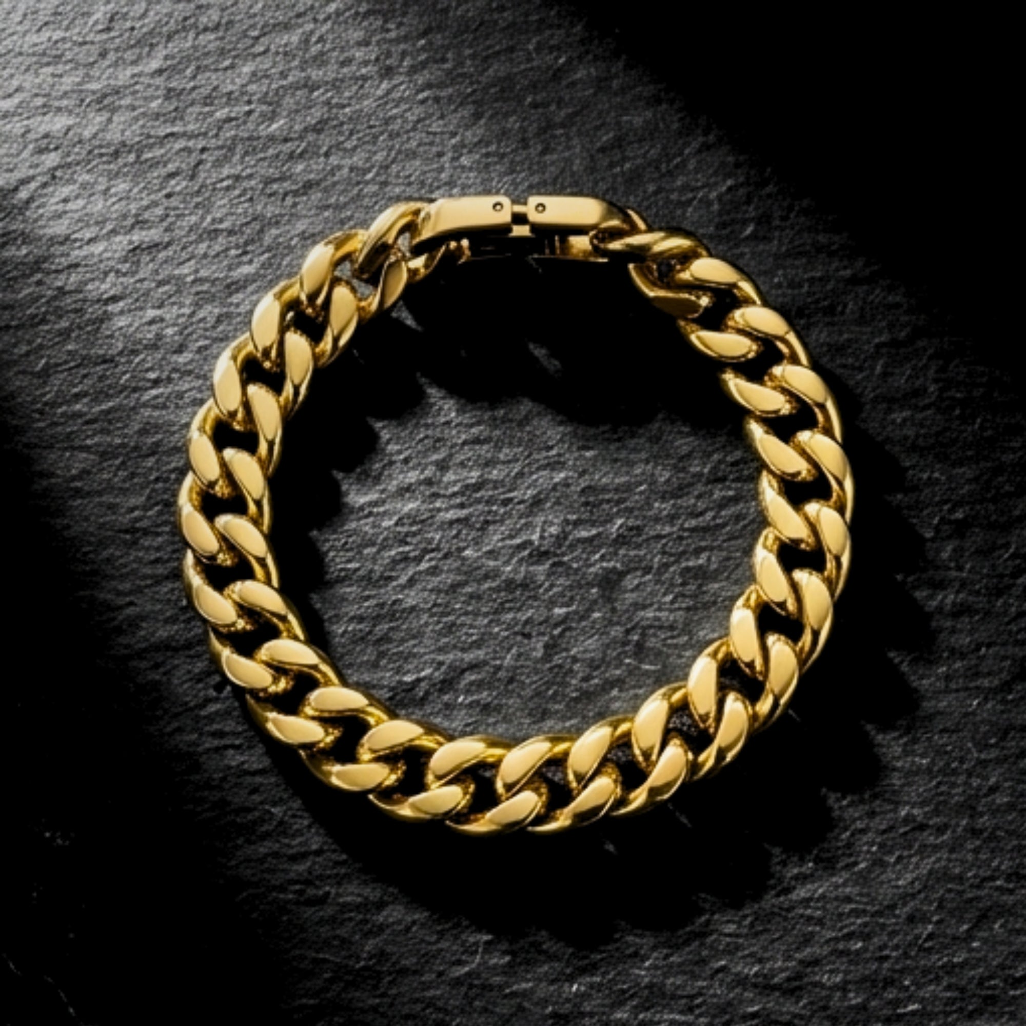 Overhead view of an 8mm gold stainless steel Cuban link bracelet on a dark slate background.