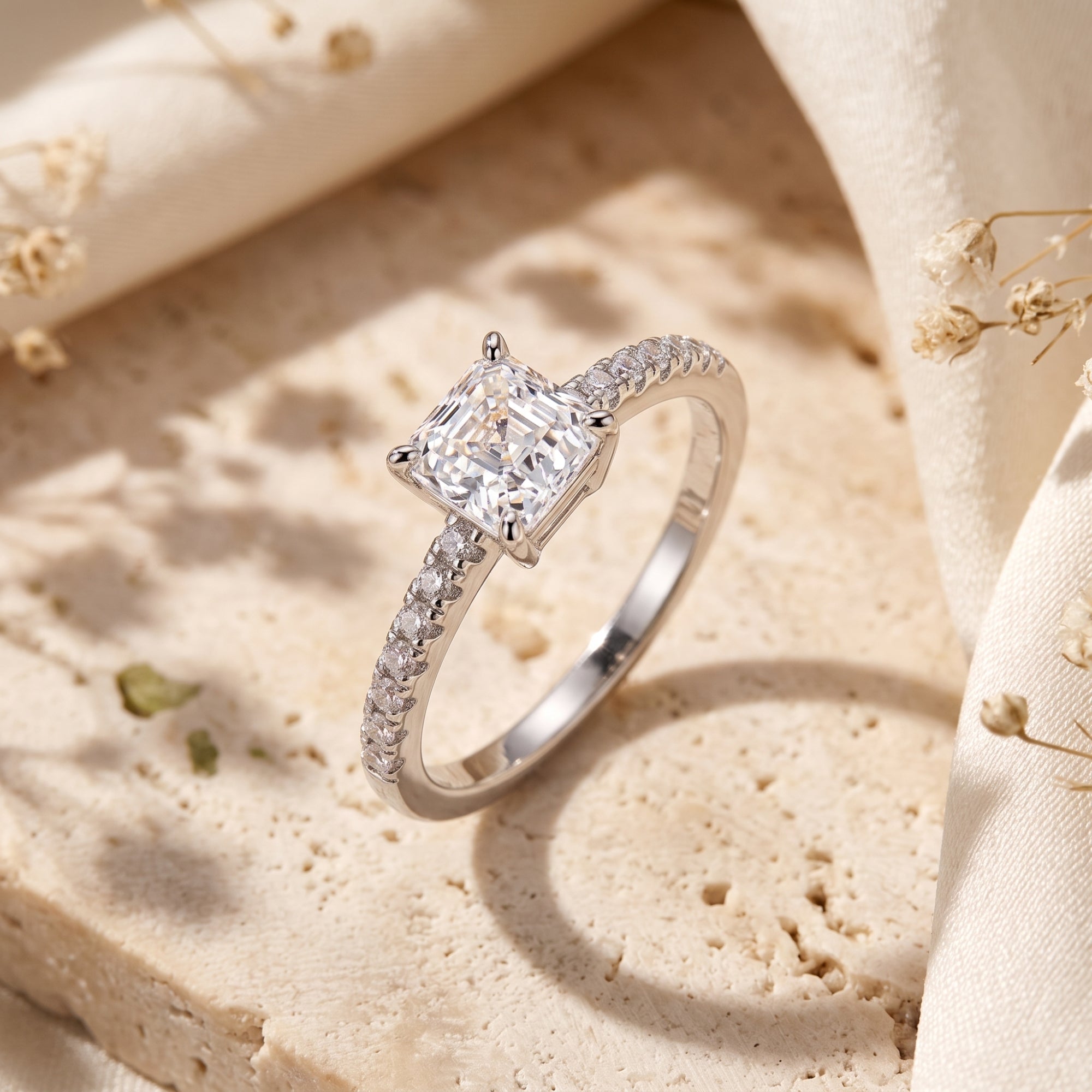 Macro view of a princess cut CZ silver ring and pavé band.