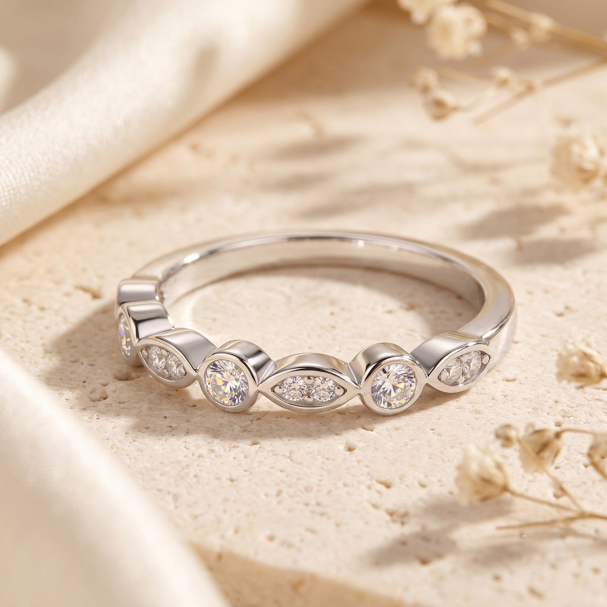 Detail of sterling silver bezel settings and round cubic zirconia stones on an eternity band.