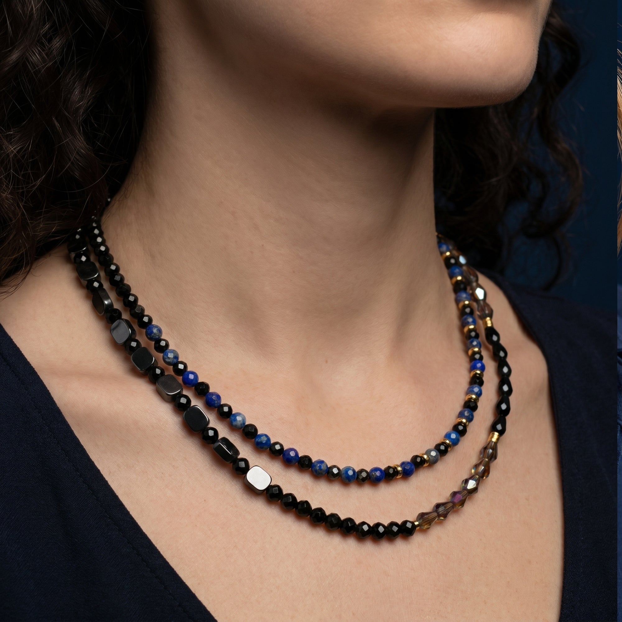 Layered gold-plated necklace with natural blue lapis and black faceted beads worn by a model.