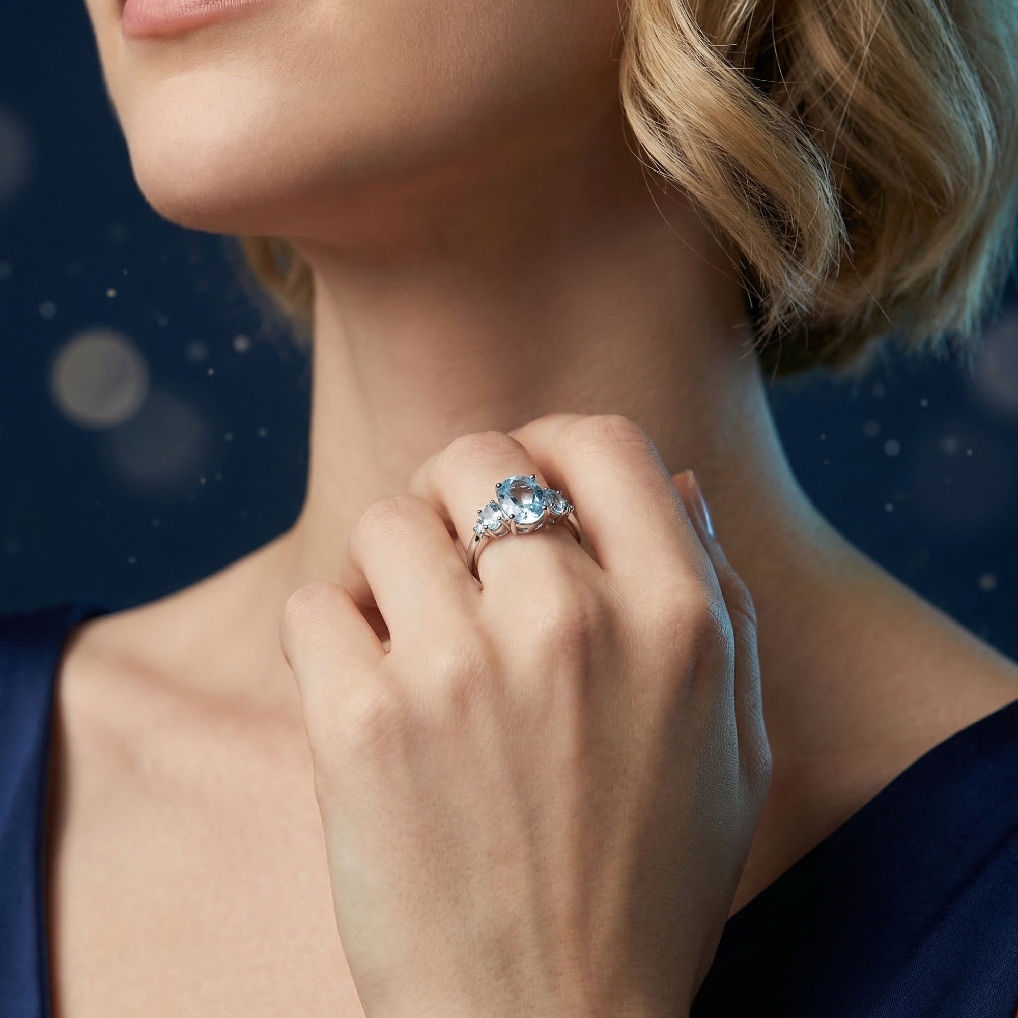 Woman wearing the Nereis oval natural blue topaz sterling silver ring in a lifestyle setting.