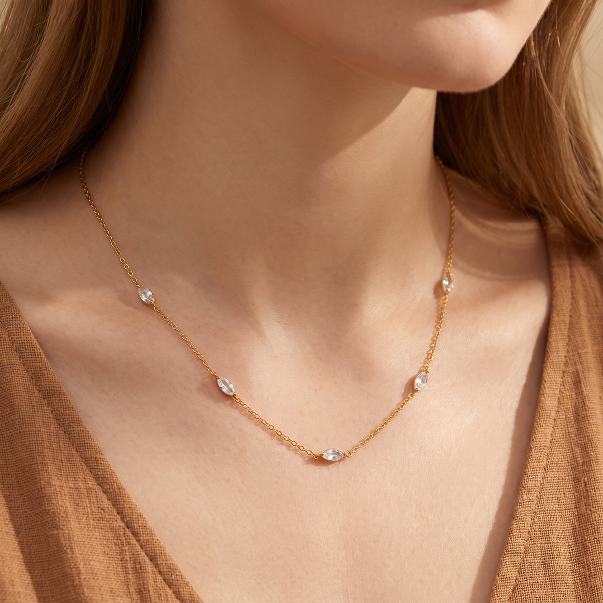 Close-up of a model wearing the gold-tone marquise station necklace with a brown knit top.