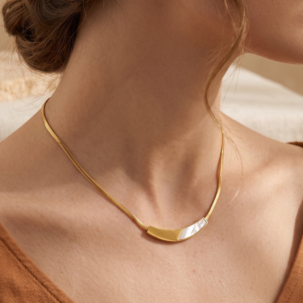Side view of a gold statement snake chain necklace with mother of pearl inlay worn by a model.