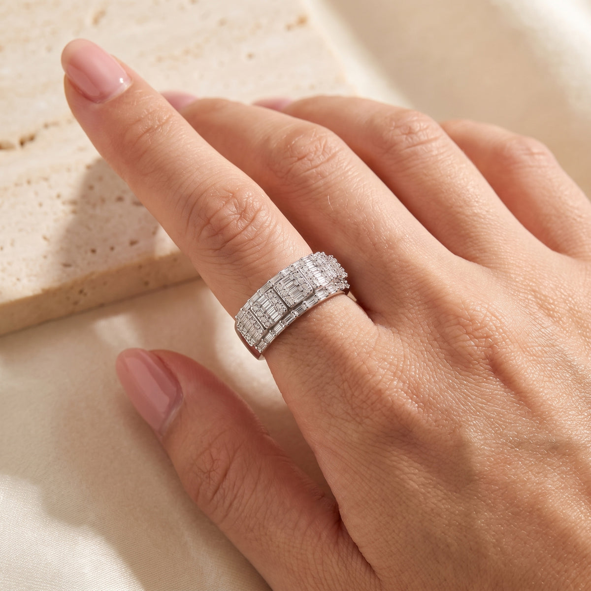 Close-up angled view of the sterling silver wide mosaic ring worn on a hand.