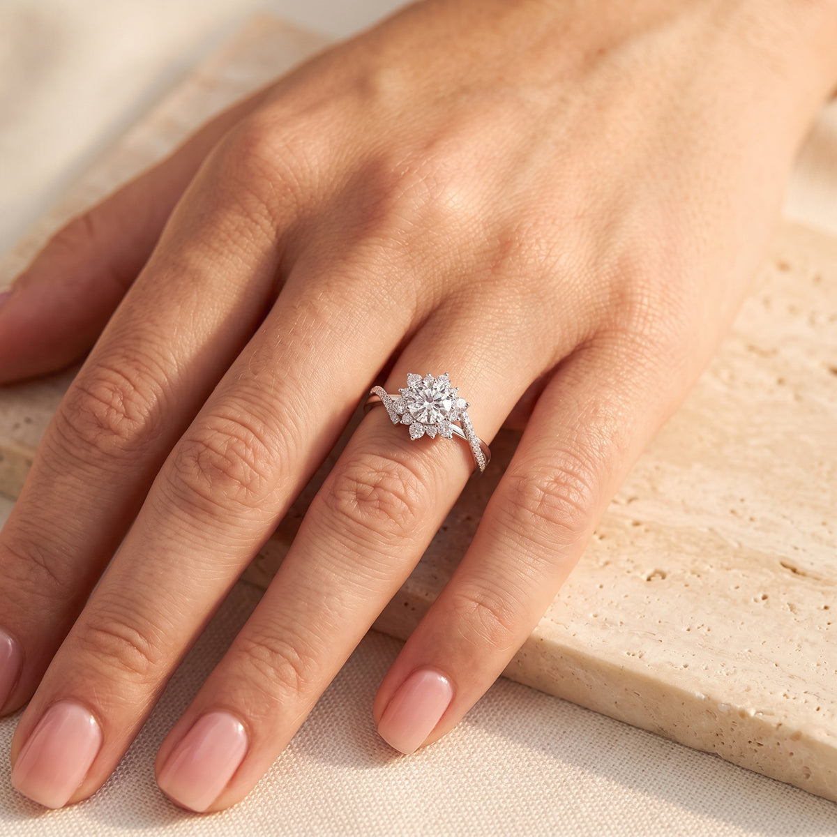 Top-down view of a hand wearing the silver cluster ring resting on a light beige stone surface.