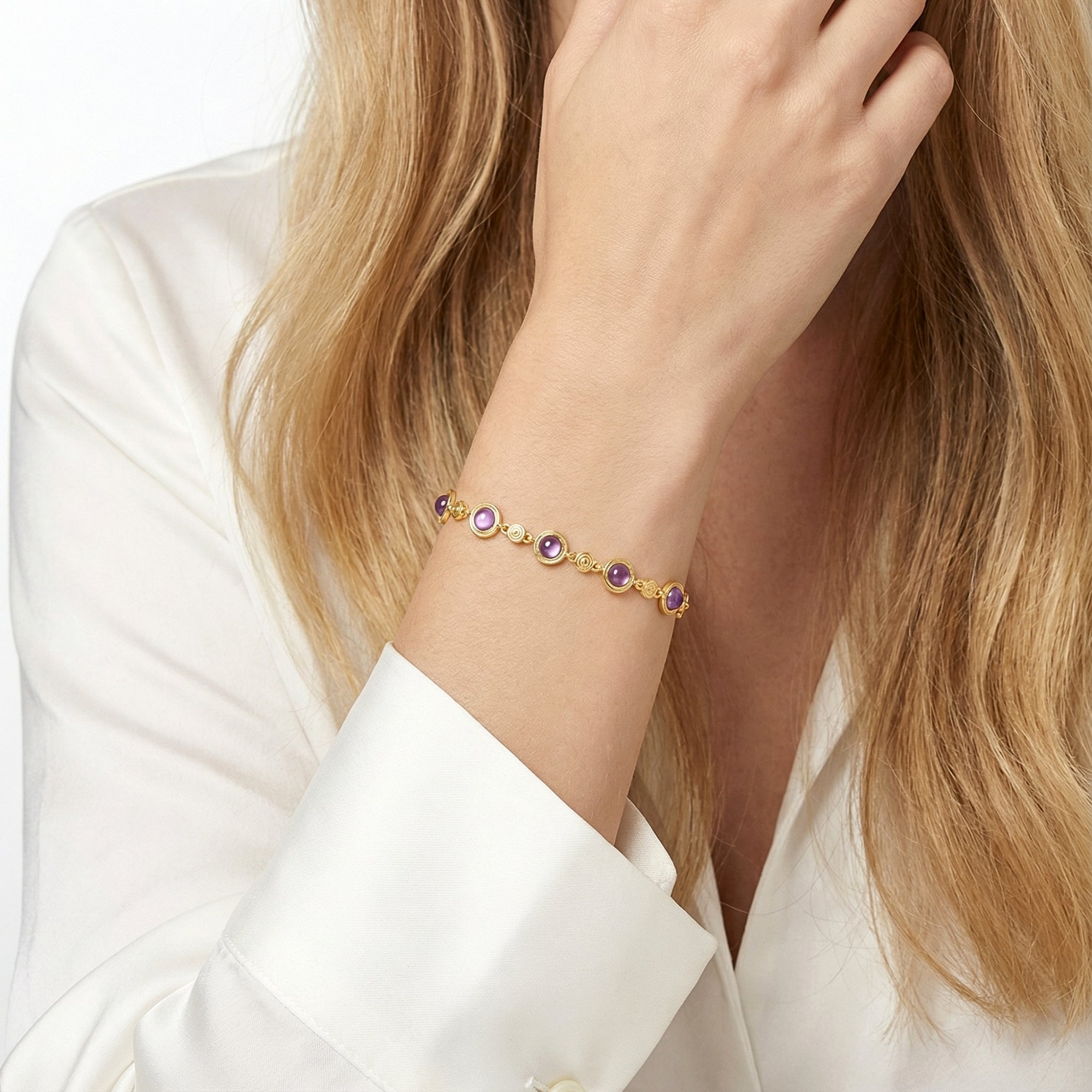 18K gold vermeil station bracelet with round cut simulated amethyst stones styled on a model's wrist.