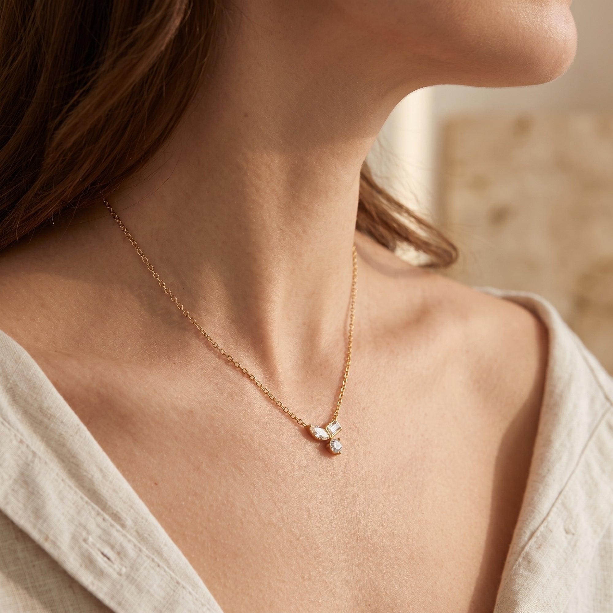 Model wearing the 18K gold Elyssara necklace with a geometric cubic zirconia pendant.
