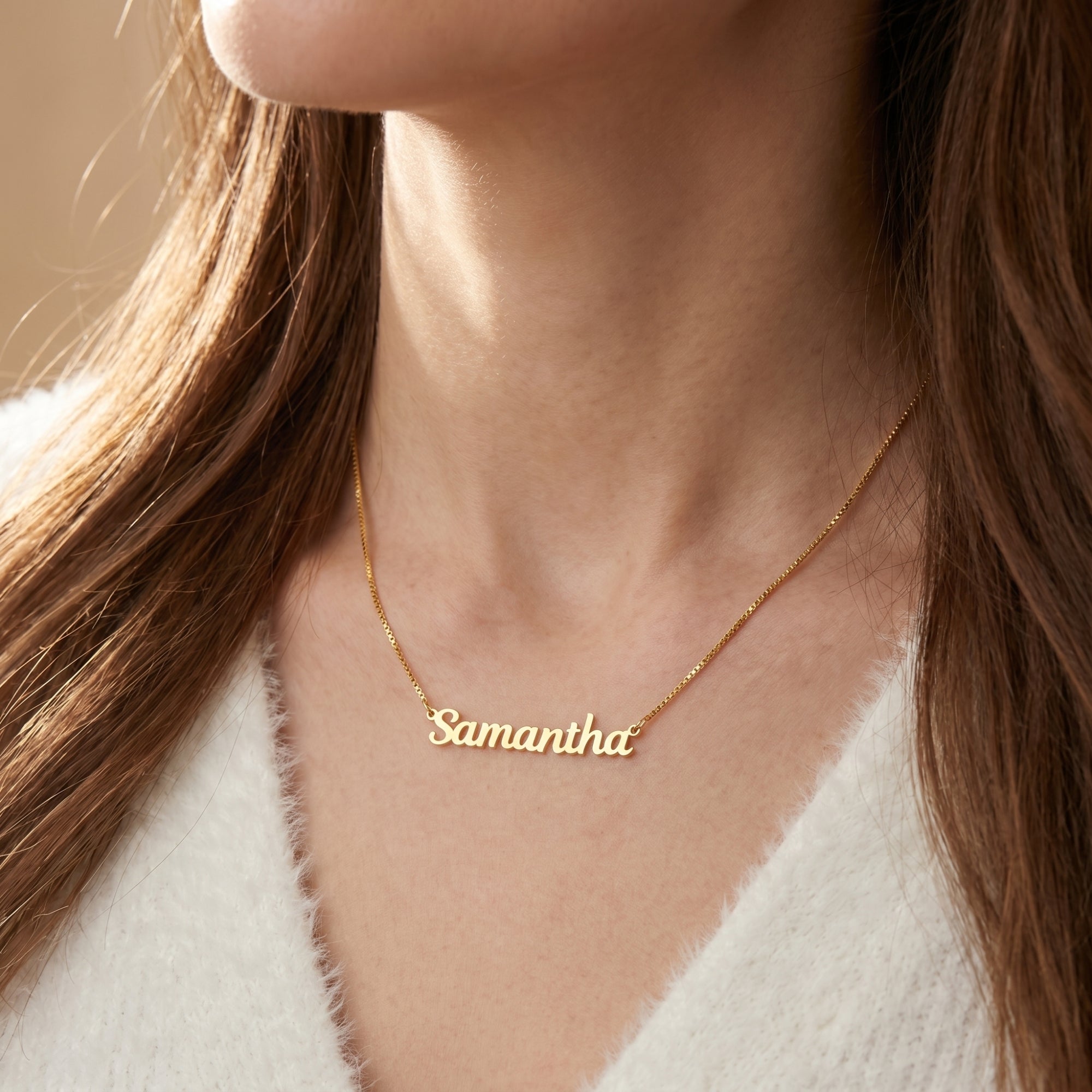 A woman wearing the 18K gold finish Noémie name necklace with the custom name Samantha on a thin chain.