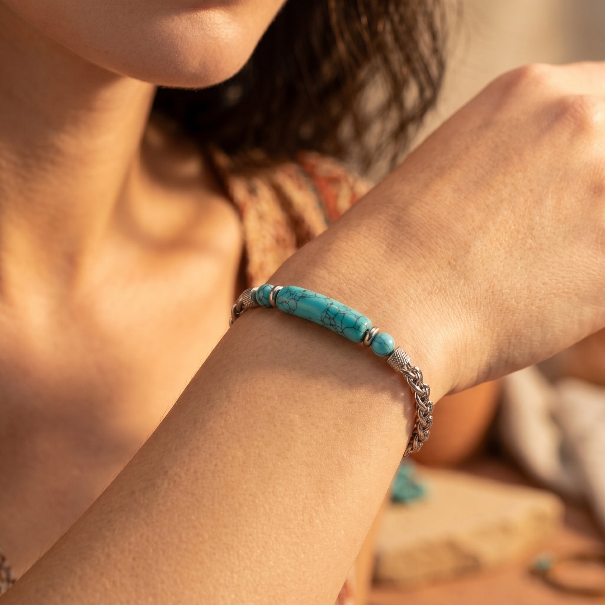 Silver stainless steel turquoise-hued bar bracelet shown on a model's wrist for a bohemian casual look.