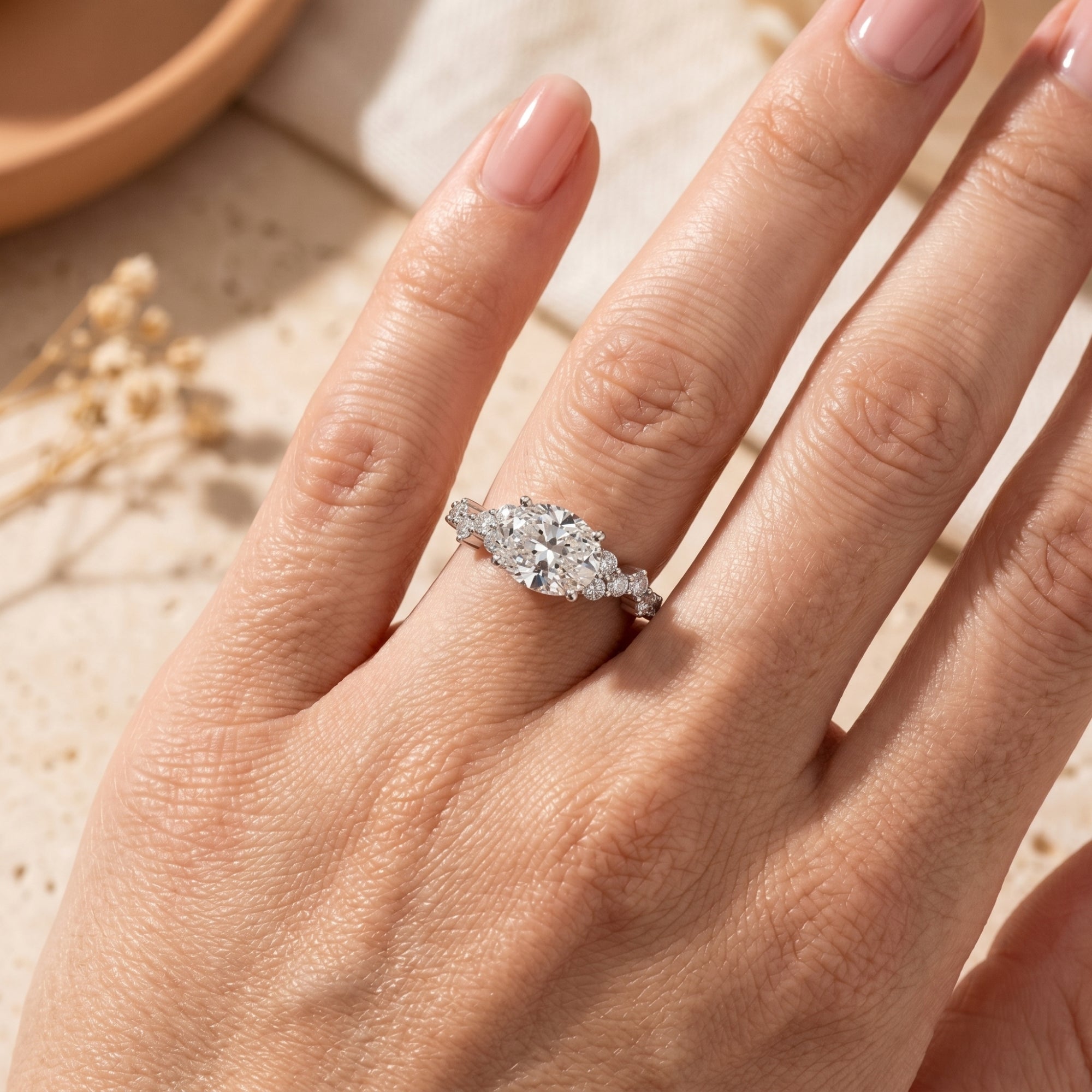 Top view of the 2-carat oval moissanite promise ring in silver worn on a woman's hand.