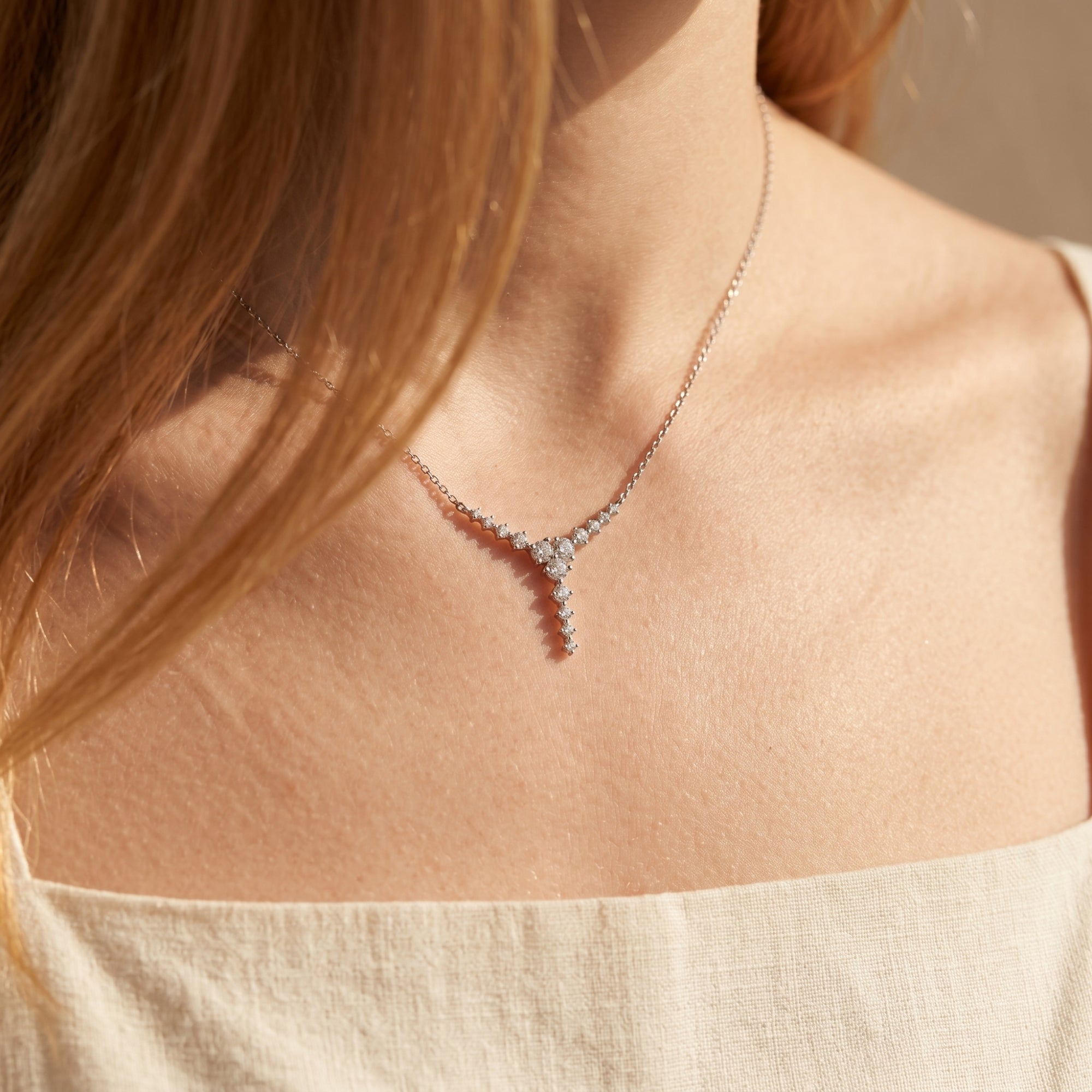 Silver moissanite cascading drop necklace worn by a model.
