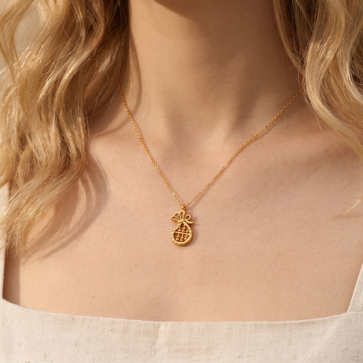 Front view of model wearing the gold-tone fortune abacus pendant necklace.