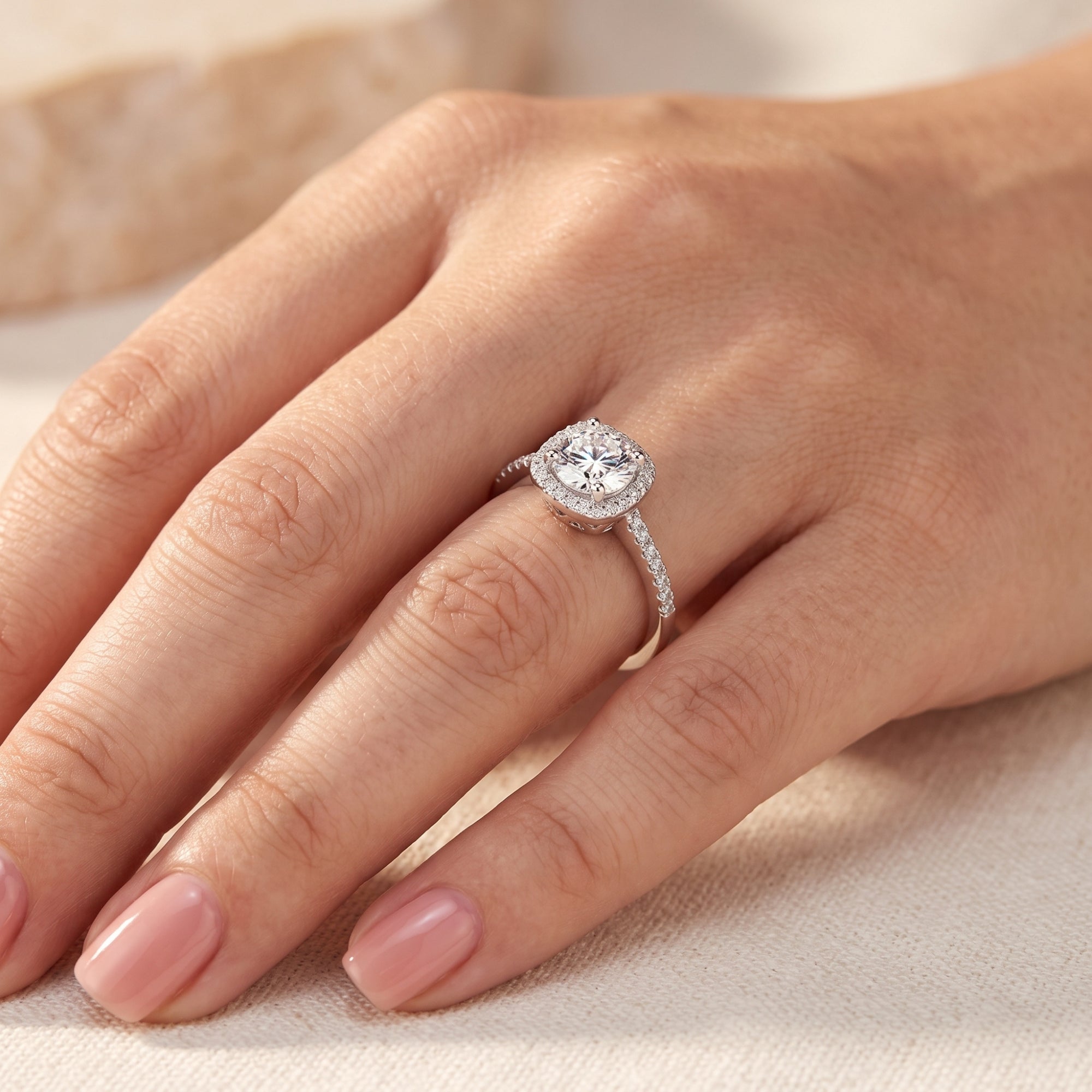 Side profile of the Elianessa round cut simulated diamond halo ring in silver S925 sterling silver on a finger.