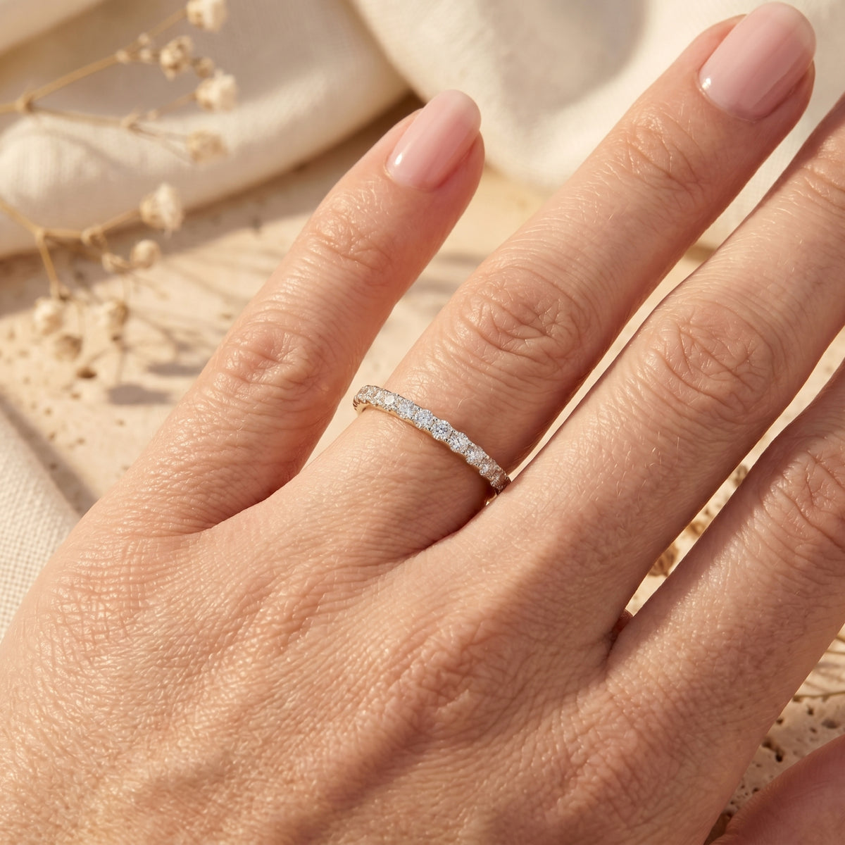 The Sylvienne sterling silver moissanite pave ring worn on a hand against a soft lifestyle background.