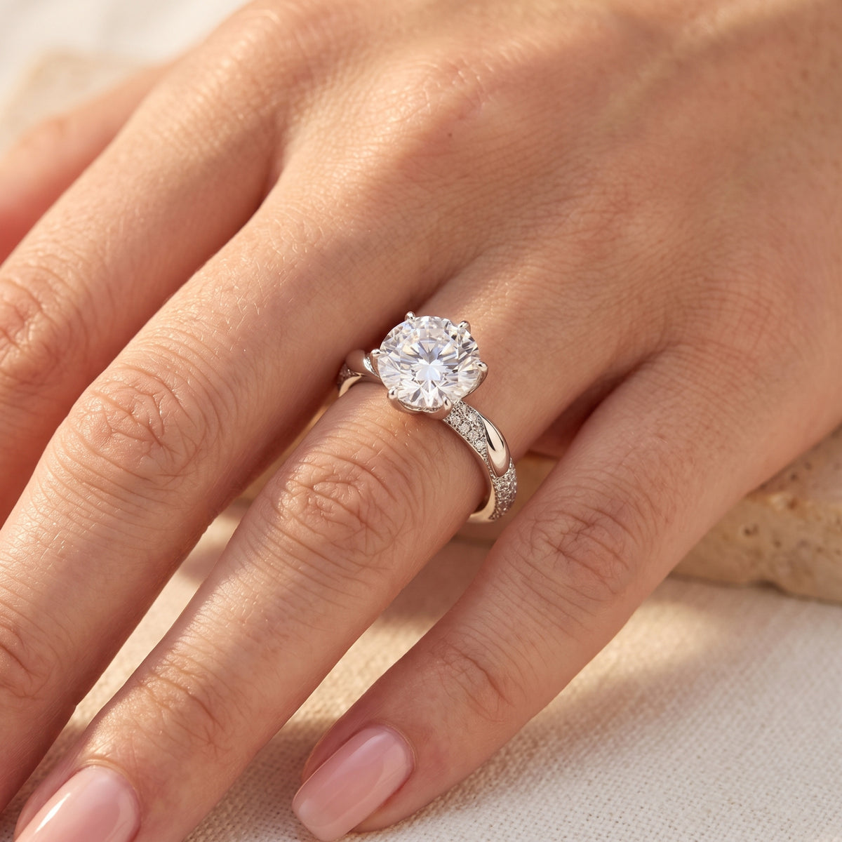 Close-up of 9mm round simulated diamond silver ring on finger for scale.