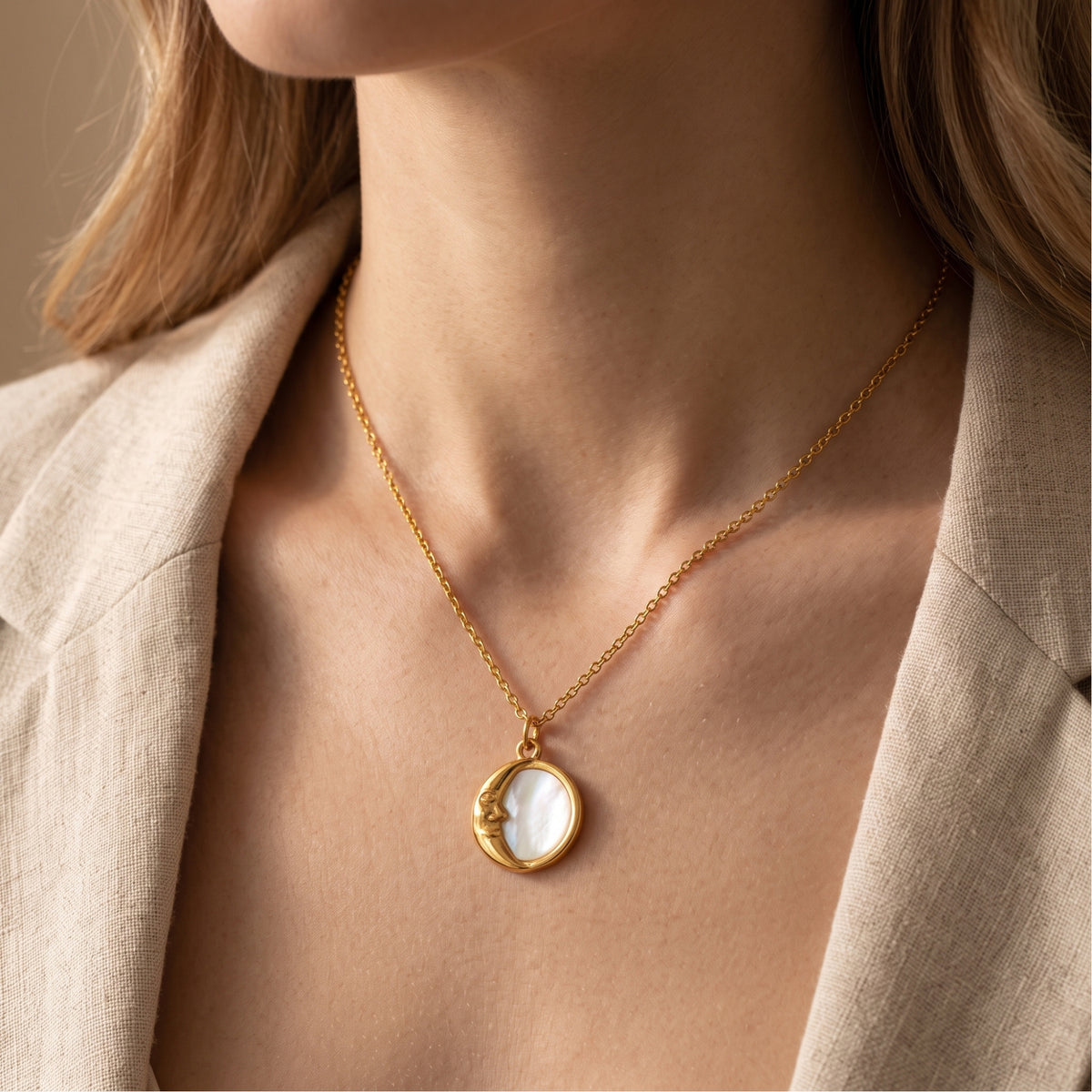 Model wearing the gold-tone crescent moon pendant necklace with a beige blazer.