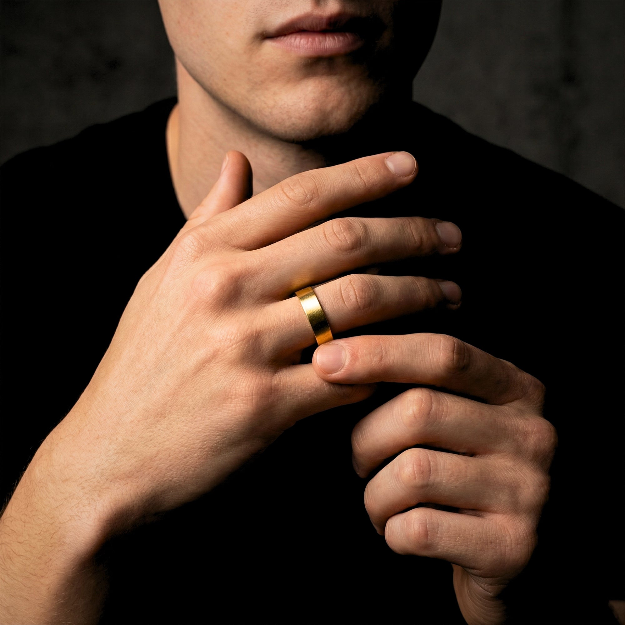 Gold stainless steel gap ring for men shown on a model's hand against a dark background.