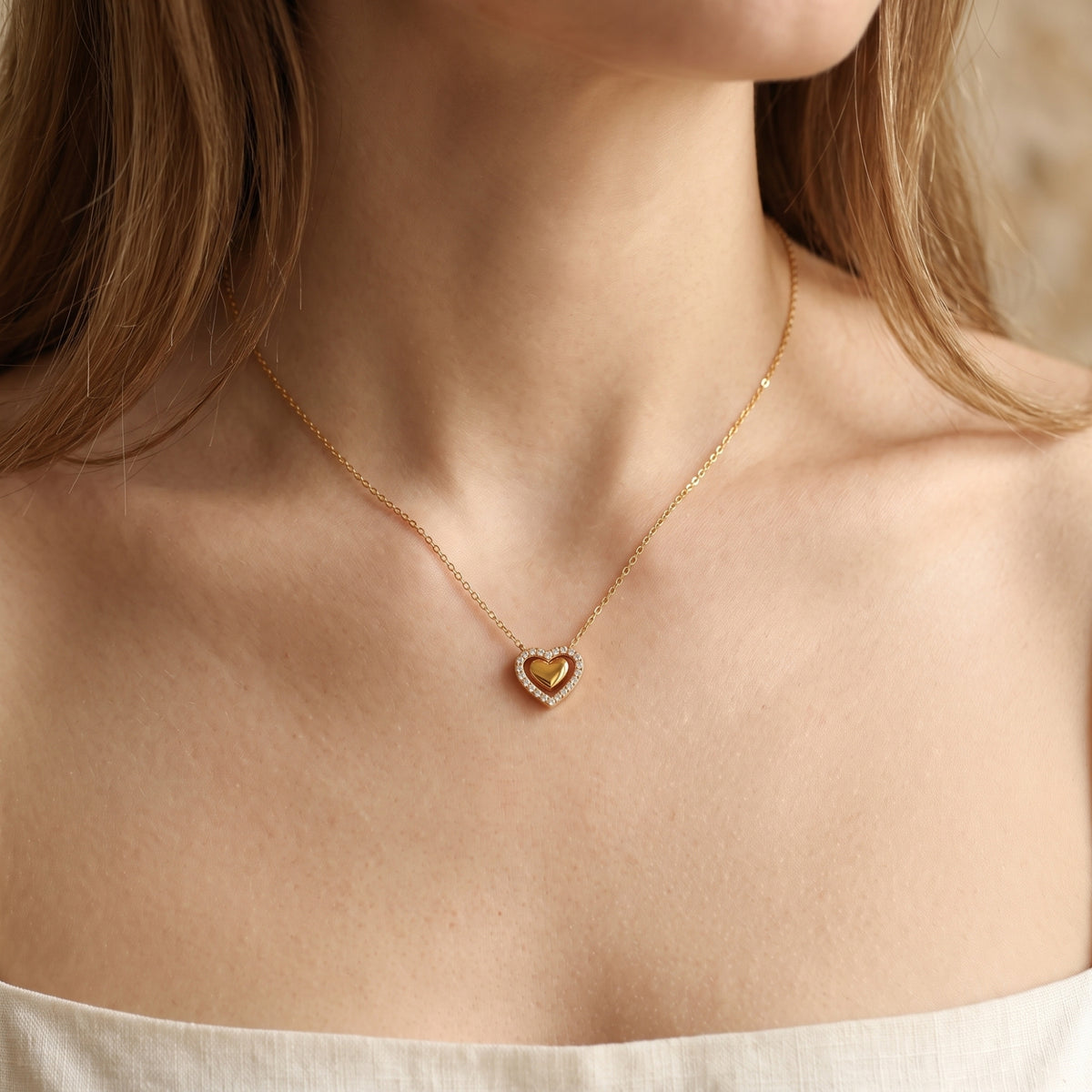 Front view of a model wearing the gold Priscilla heart pendant necklace with a cubic zirconia halo.