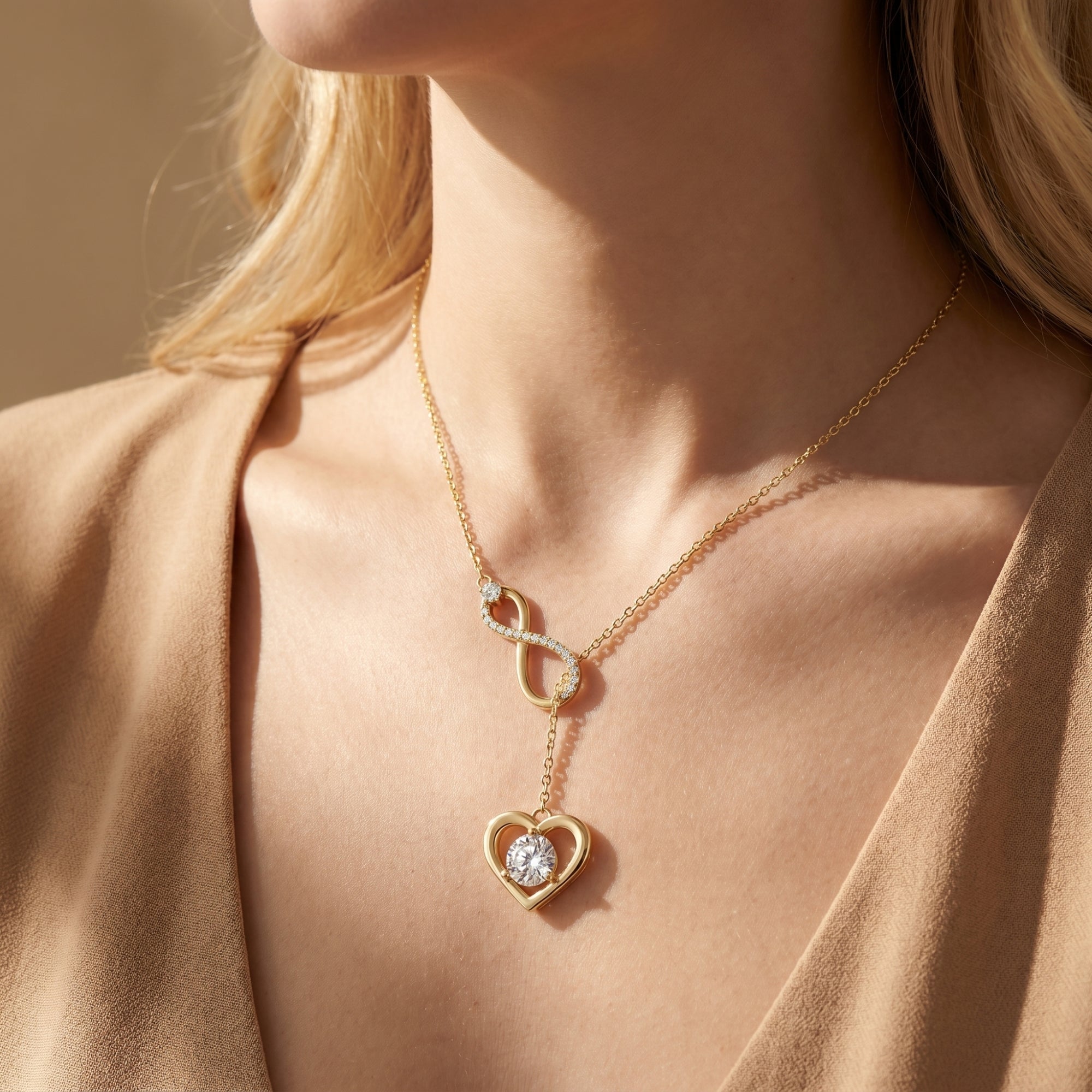 Close-up of a woman wearing the gold infinity heart moissanite necklace with a V-neck top.