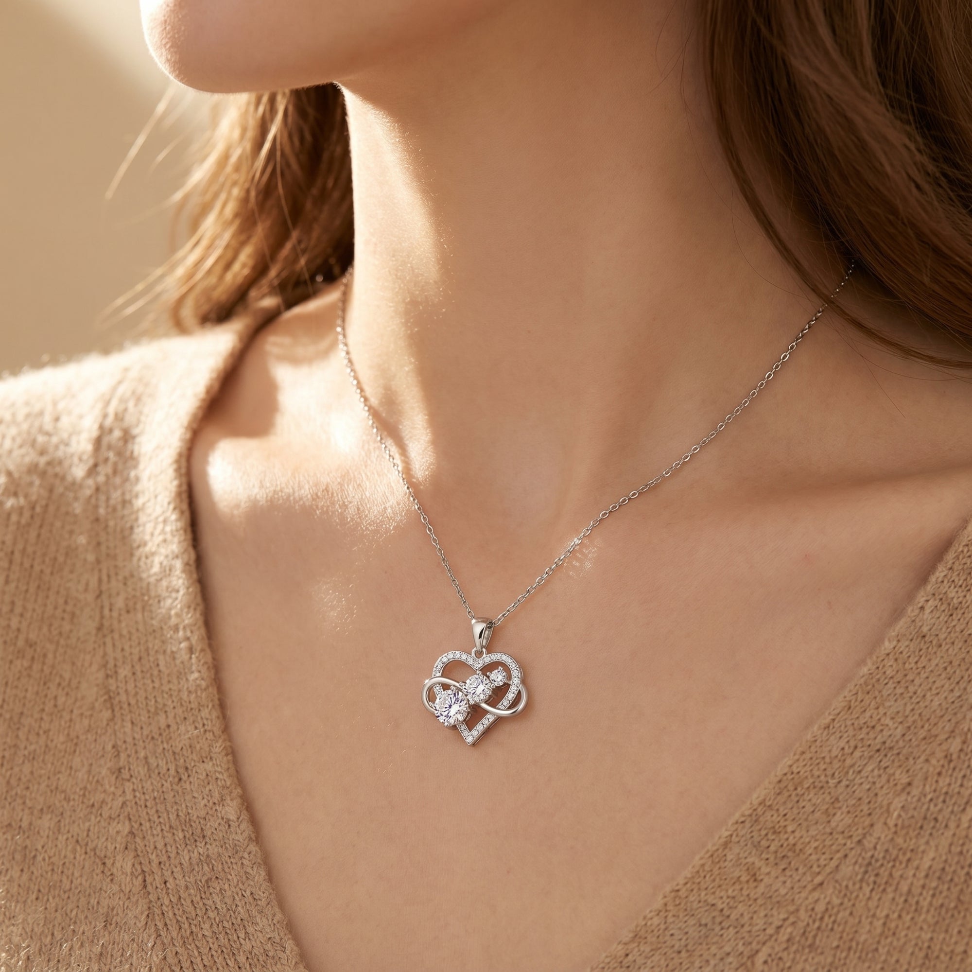 Gold Aureliette moissanite heart and infinity pendant necklace shown on a model.