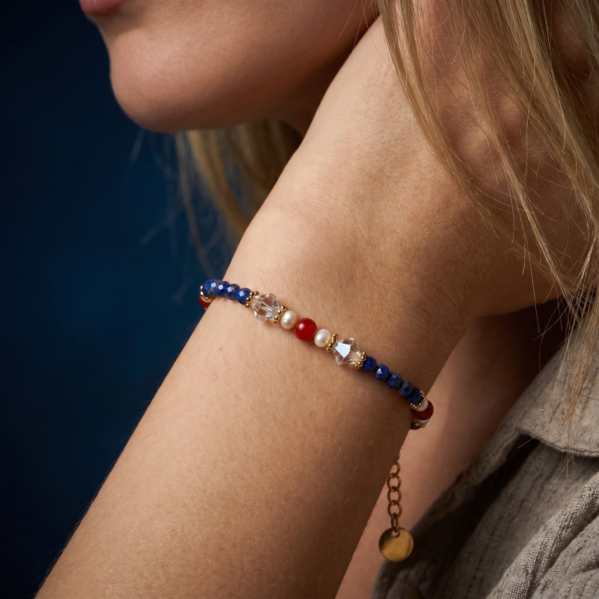 Close-up of the gold plated lapis lazuli and pearl bead bracelet on a model's wrist.
