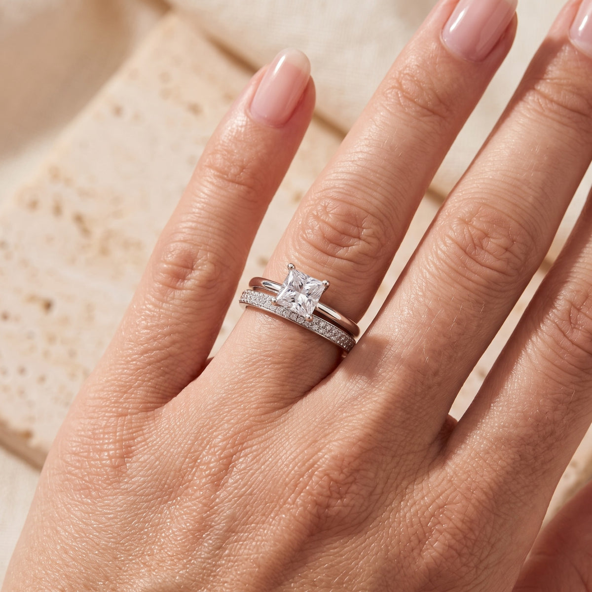 Macro view of a princess cut simulated diamond and pavé band in sterling silver.