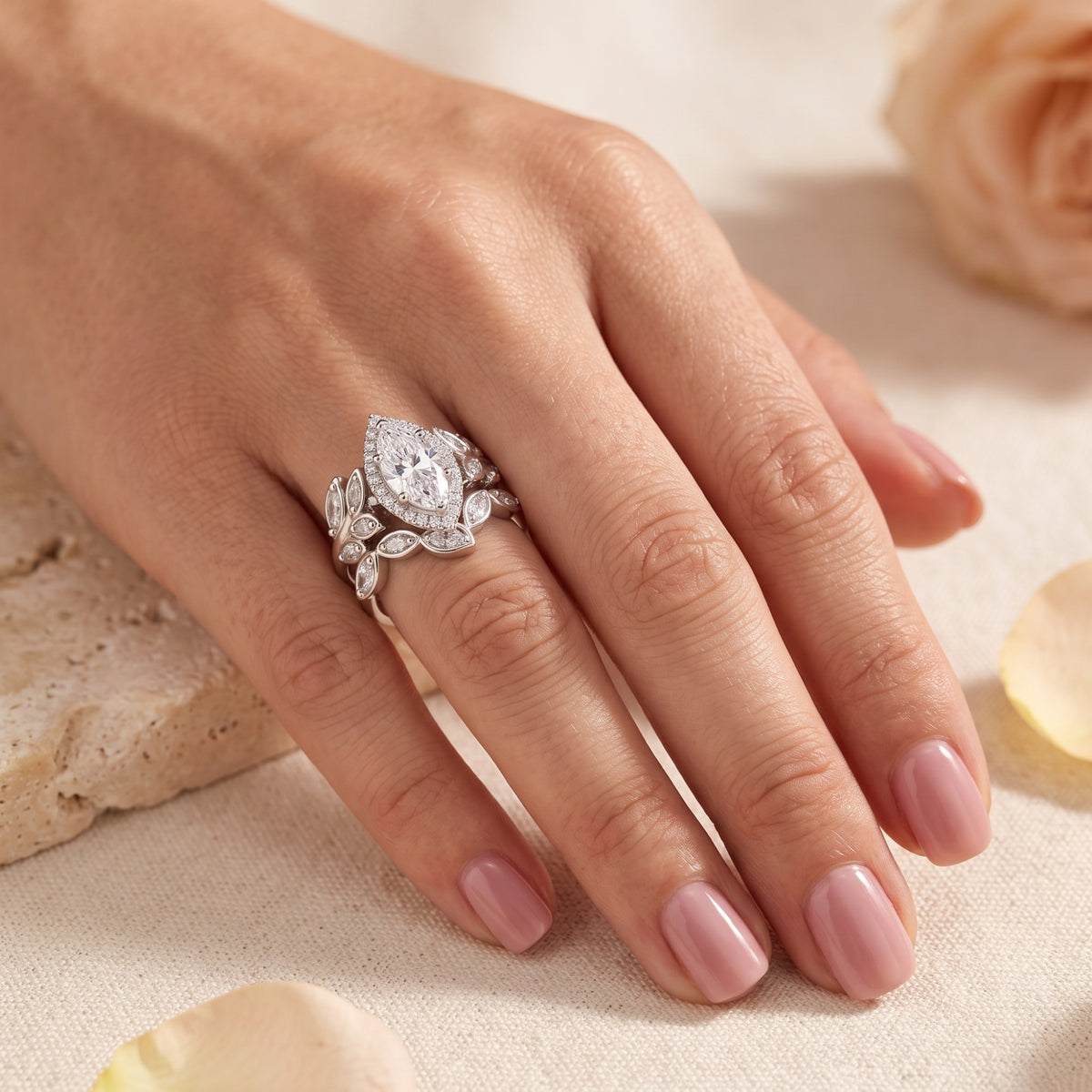Sterling silver marquise simulated diamond ring set worn on a finger with rose petals.
