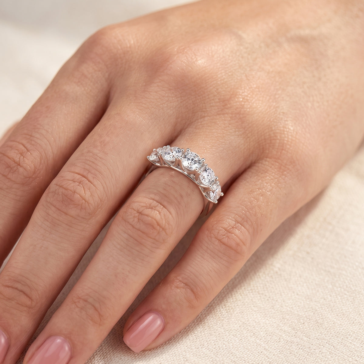 Angled view of the Claralise sterling silver five-stone round-cut simulated diamond ring worn on a woman's hand.