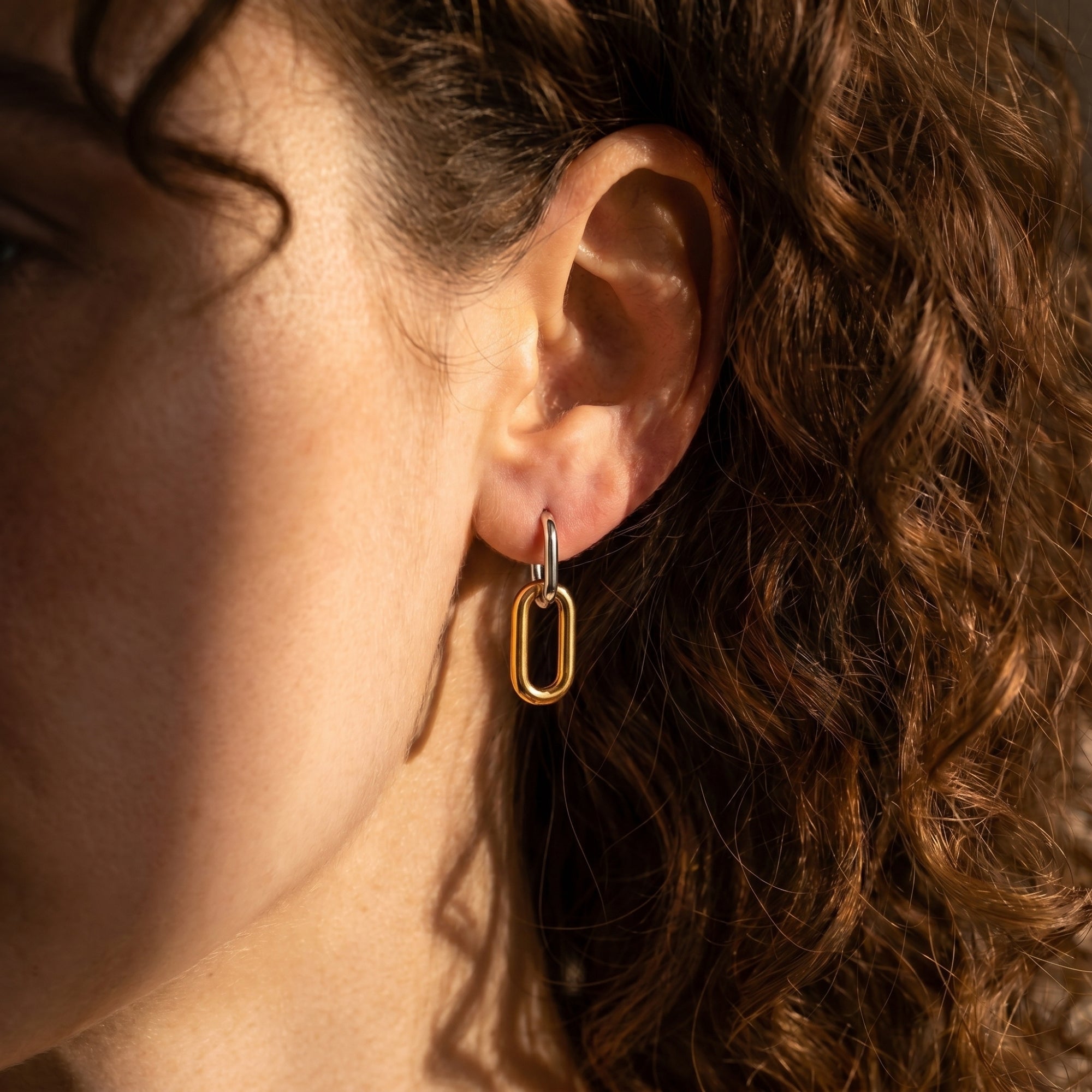 Close-up of a model wearing the Ashlyn two-tone silver and gold drop earrings.