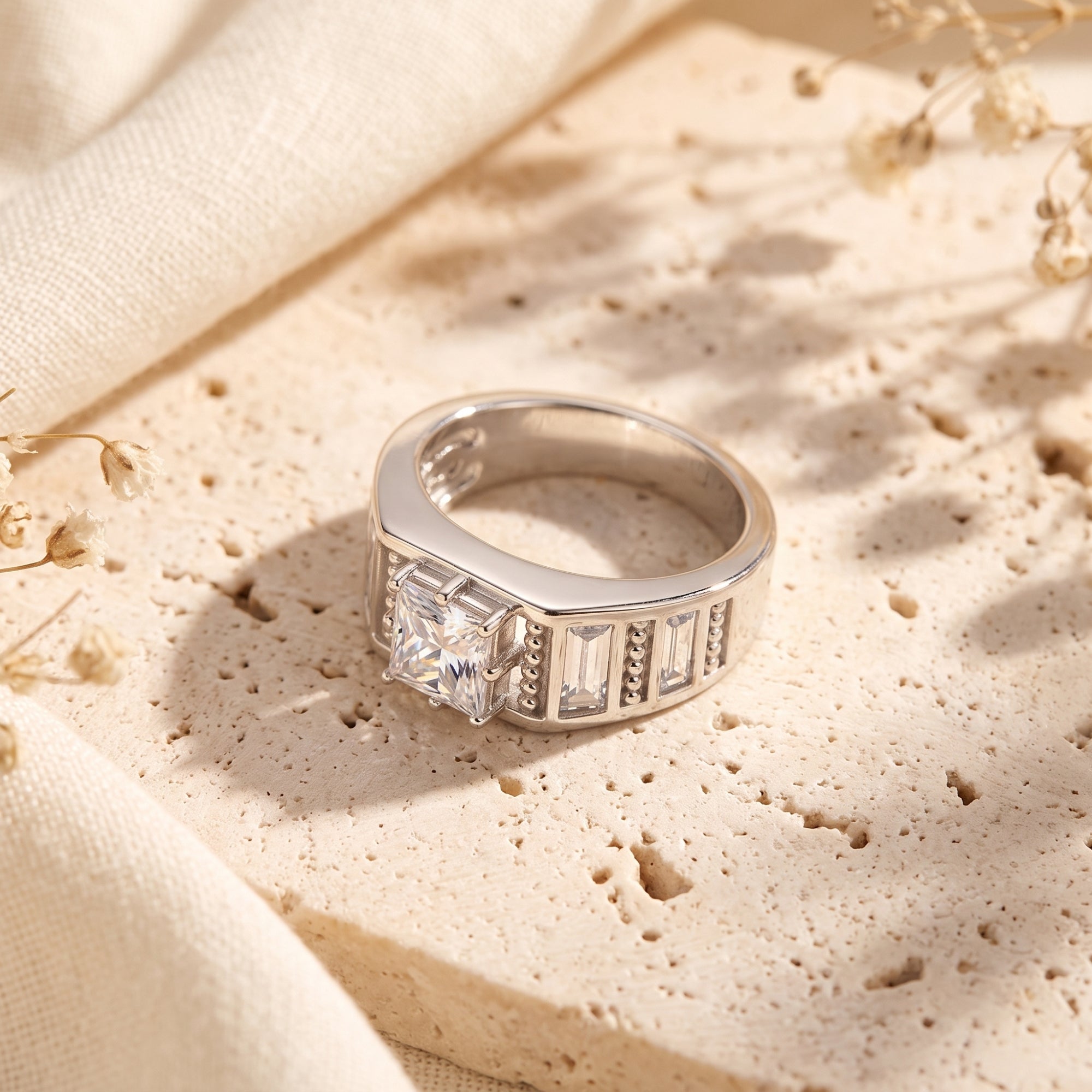 Angled side view of the S925 sterling silver Carisara ring showing the princess cut center and baguette stones.