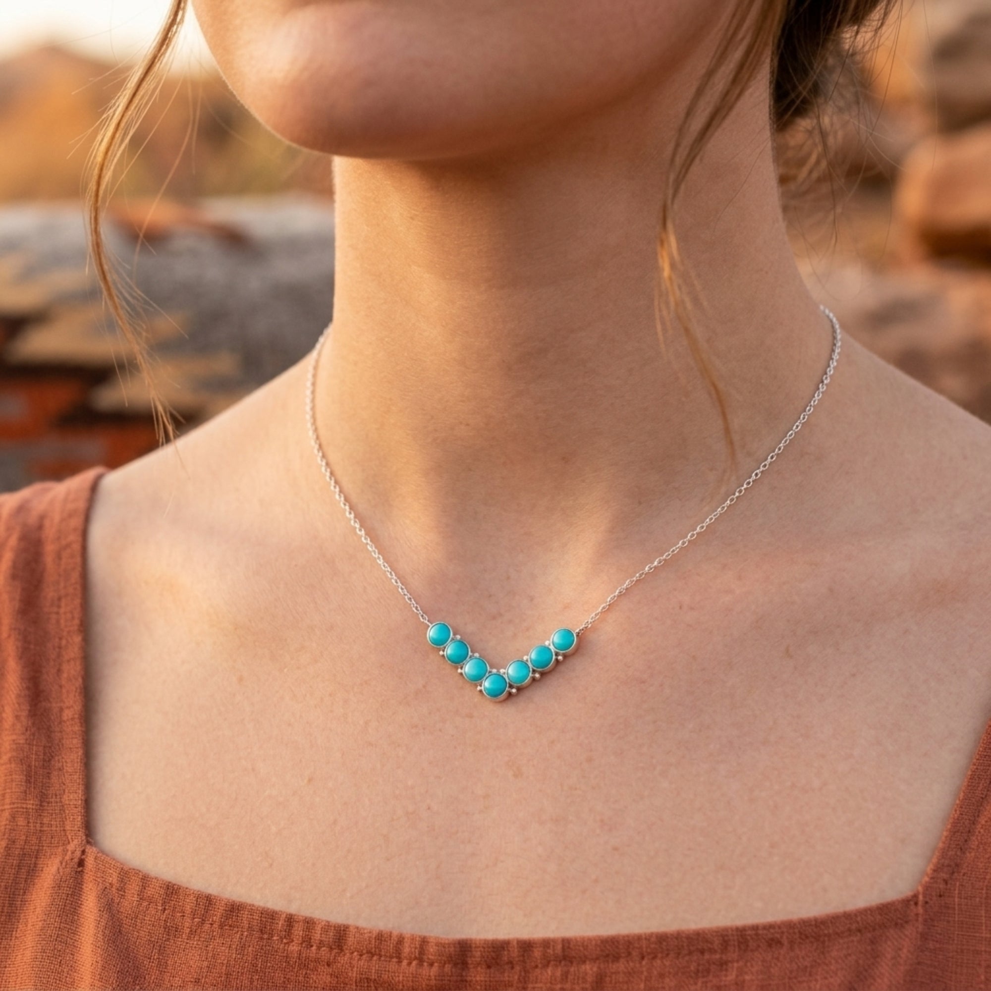 Model wearing the silver Navajo-style turquoise bead necklace outdoors.