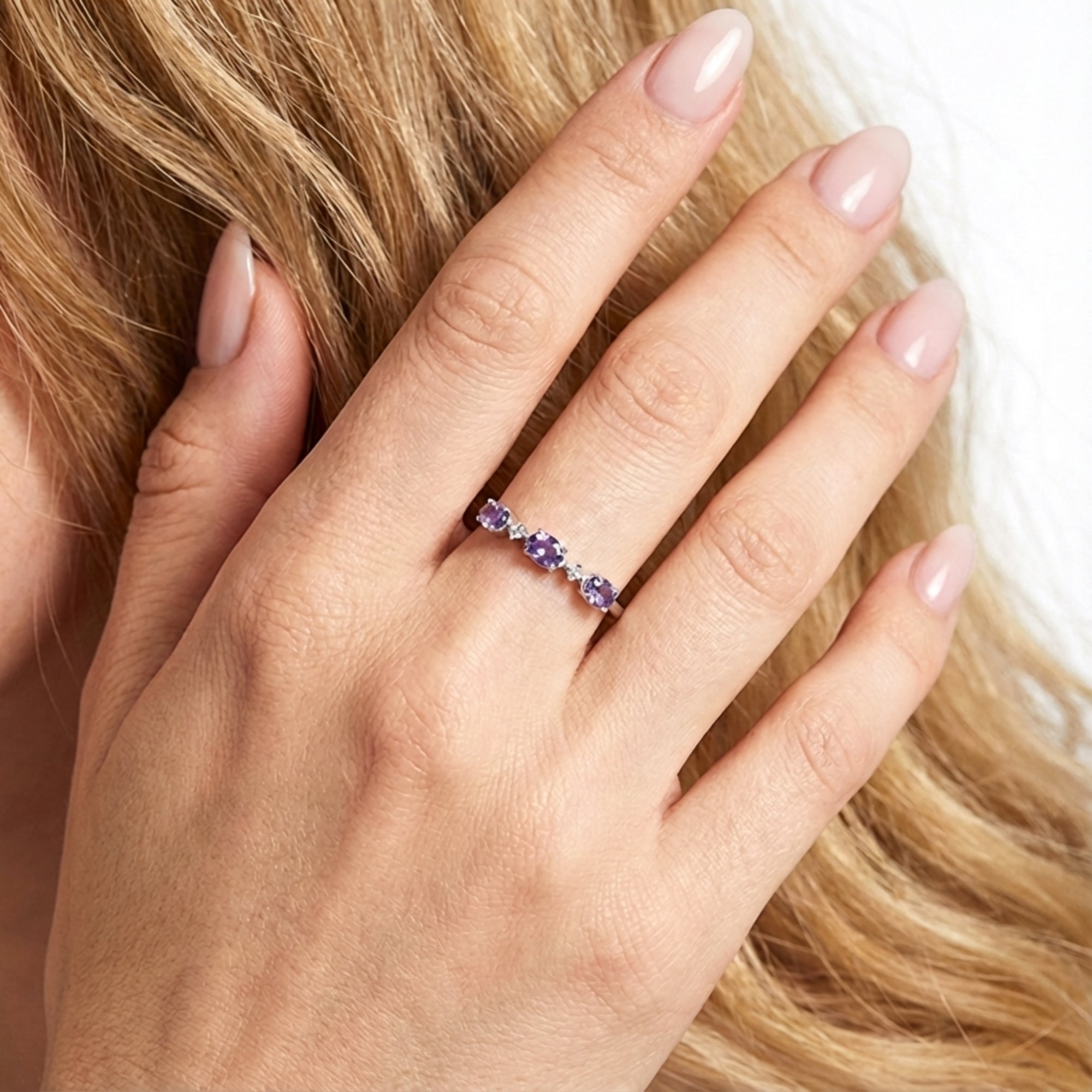 Close-up of the Serenitas S925 sterling silver simulated amethyst ring on a woman's hand for scale.