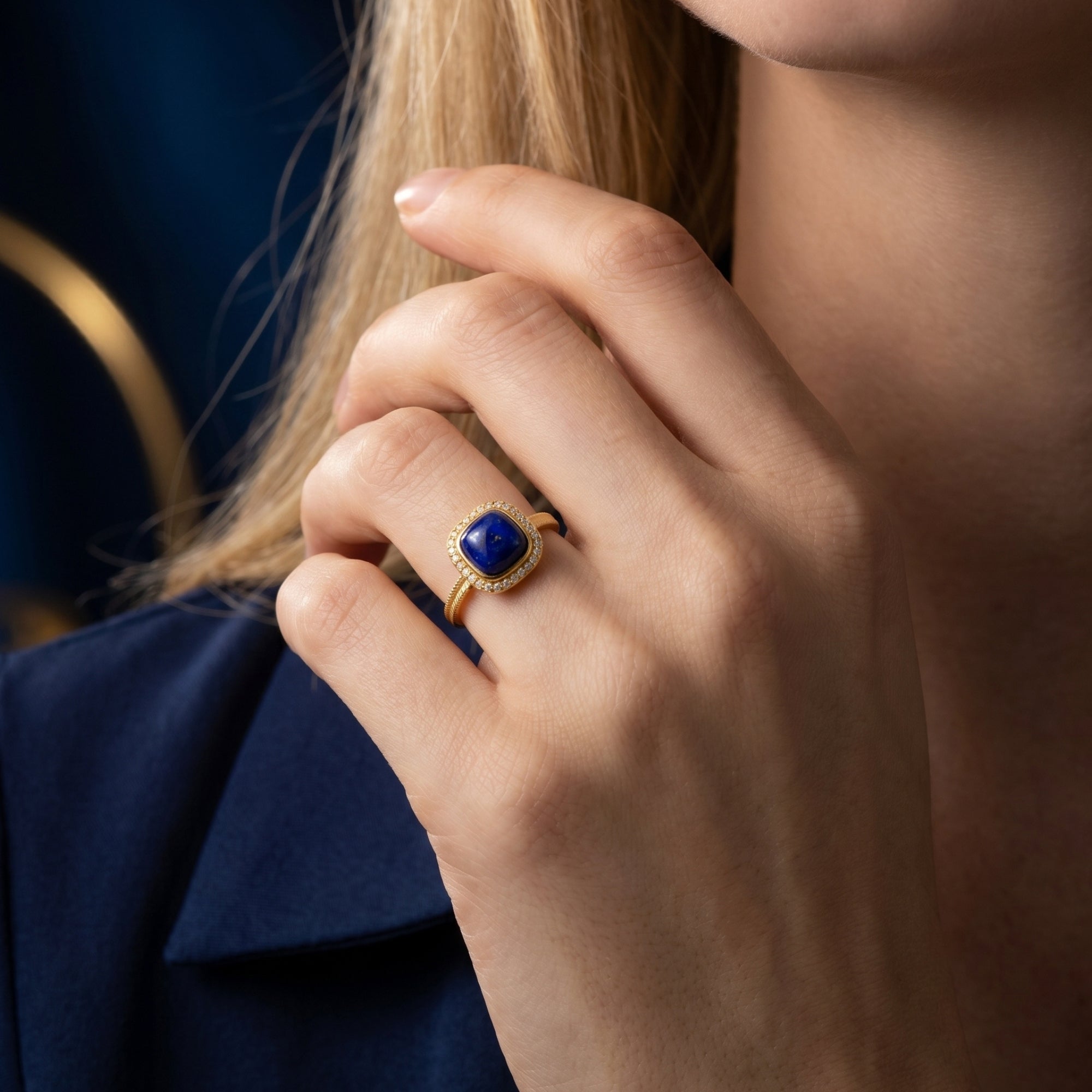 Gold plated sterling silver ring featuring a square natural lapis lazuli gemstone worn on a model's hand.