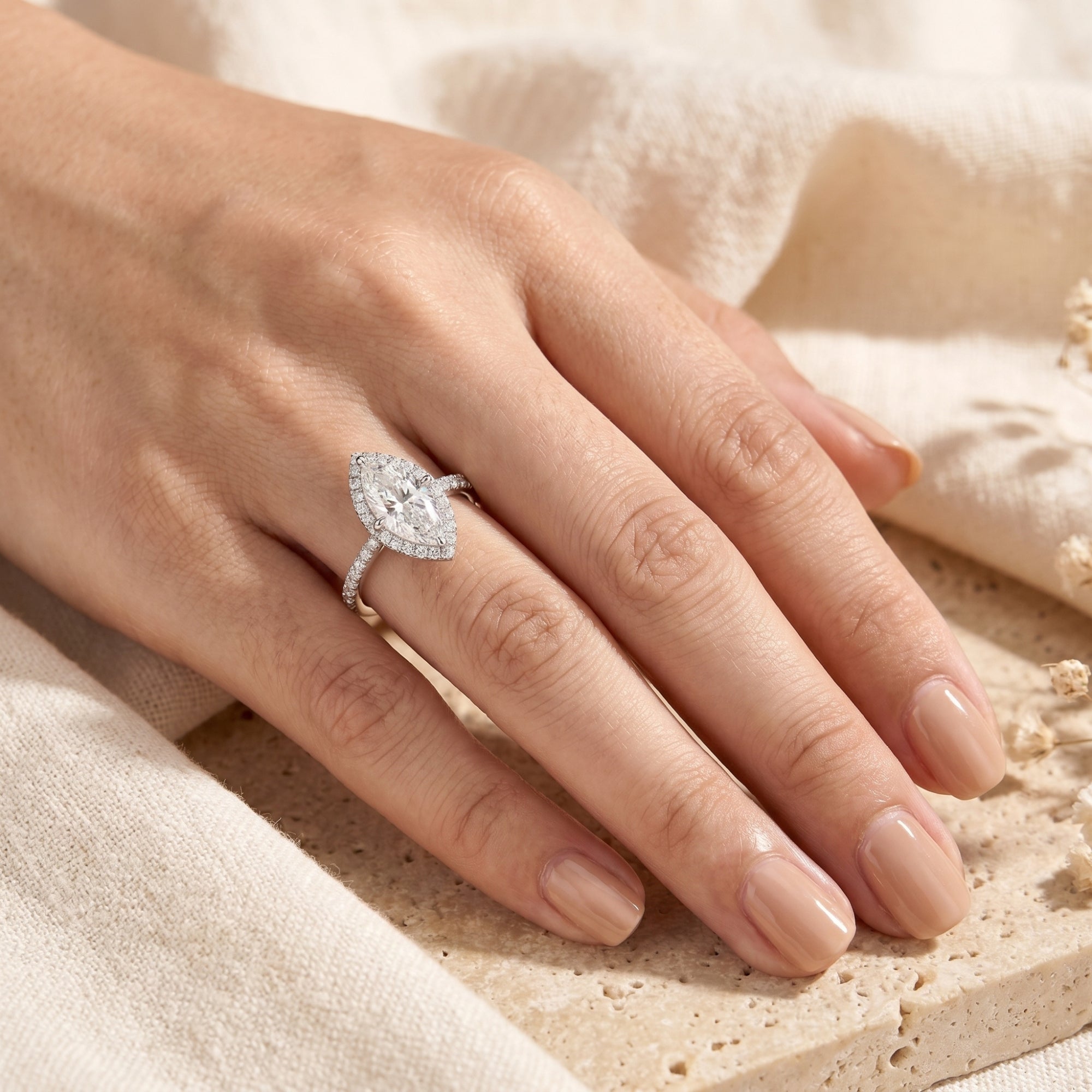 Sterling silver marquise moissanite halo ring displayed on a hand for scale reference.