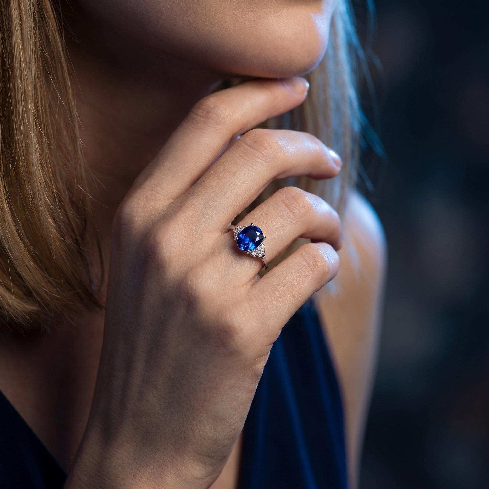 A woman wearing the 18K white gold oval tanzanite ring, showing the gemstone's deep blue color on her hand.