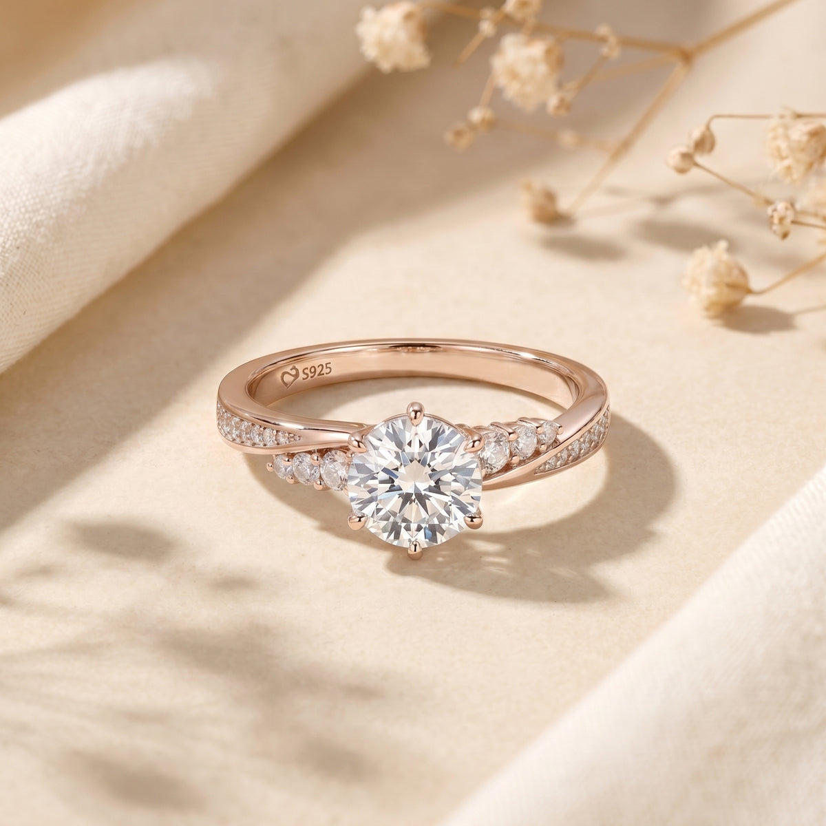 Rose gold Nicolette ring with a 2ct round-cut moissanite center stone on a styled lifestyle background.