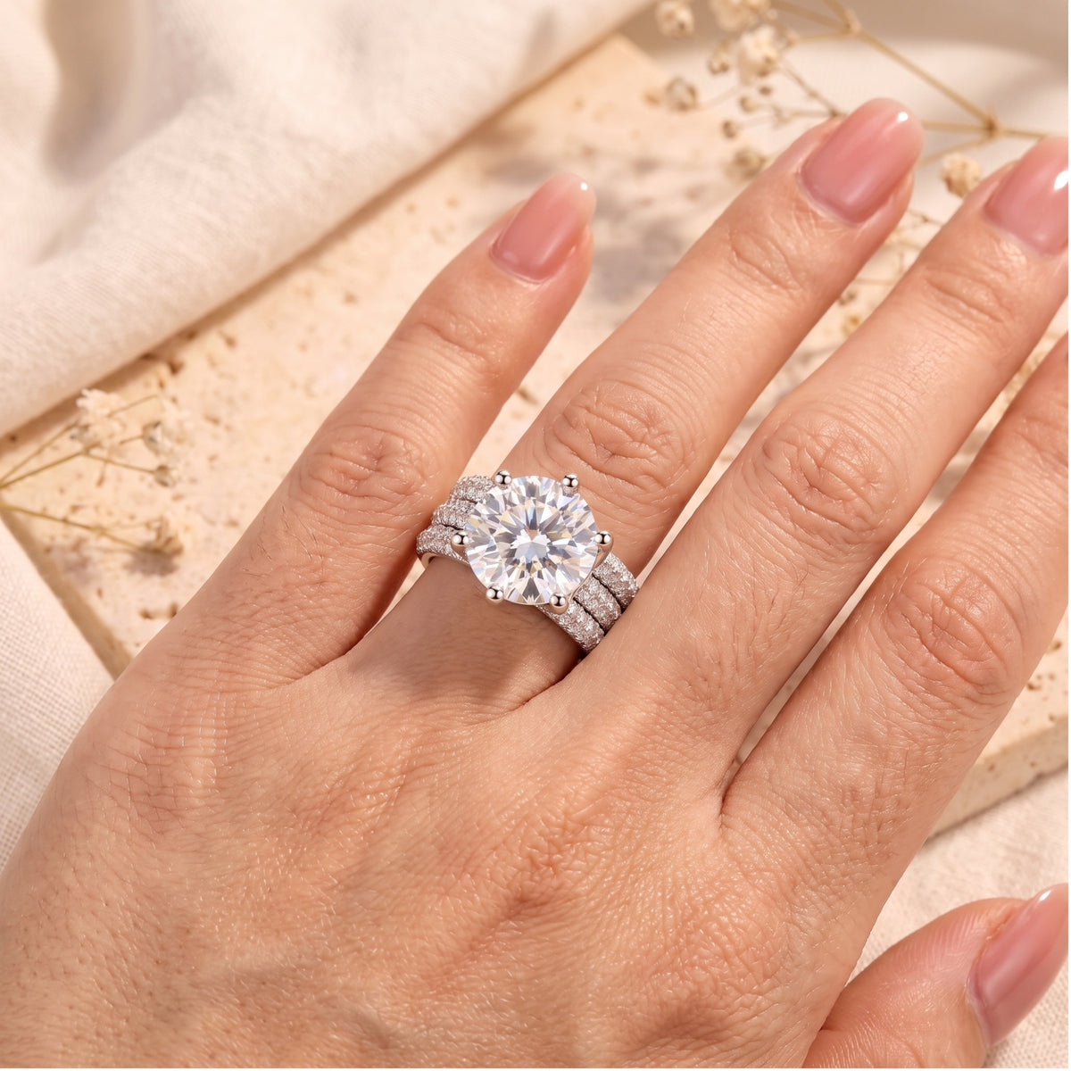 Top view of large round simulated diamond silver ring worn on finger.