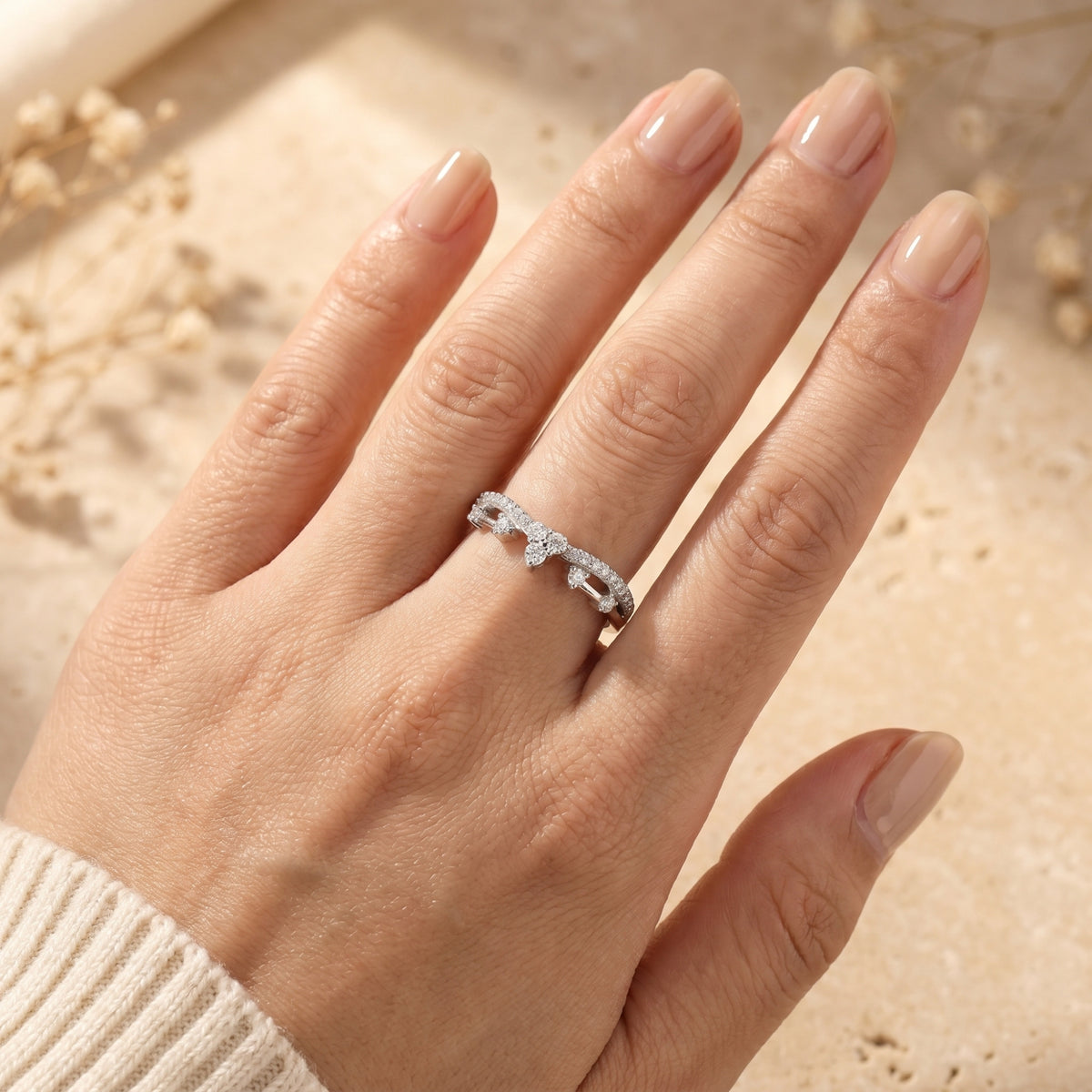 Top view of the silver Ismerelle crown ring with sparkling simulated diamonds on a model's finger.