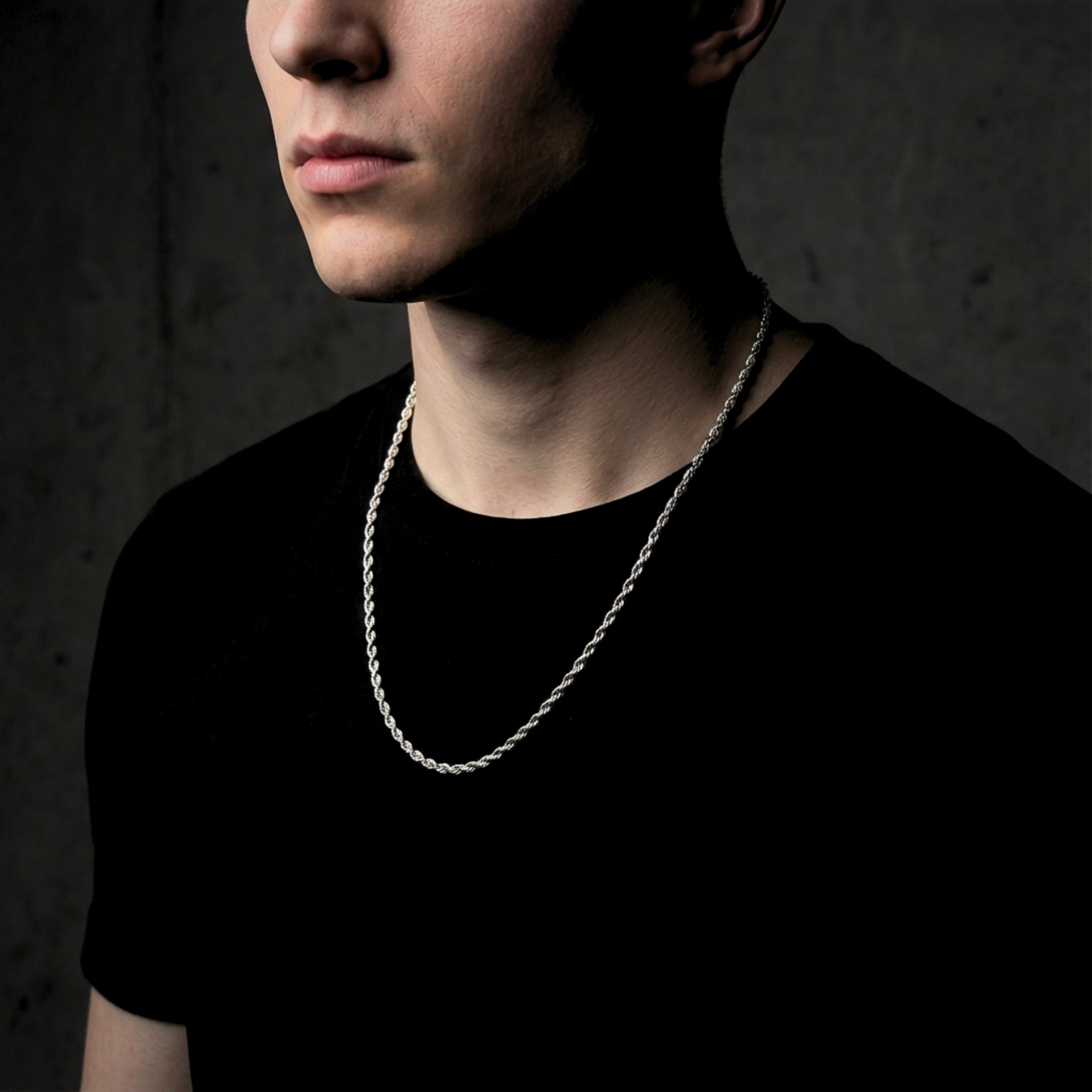 Men's silver stainless steel rope chain worn by a model over a black t-shirt.