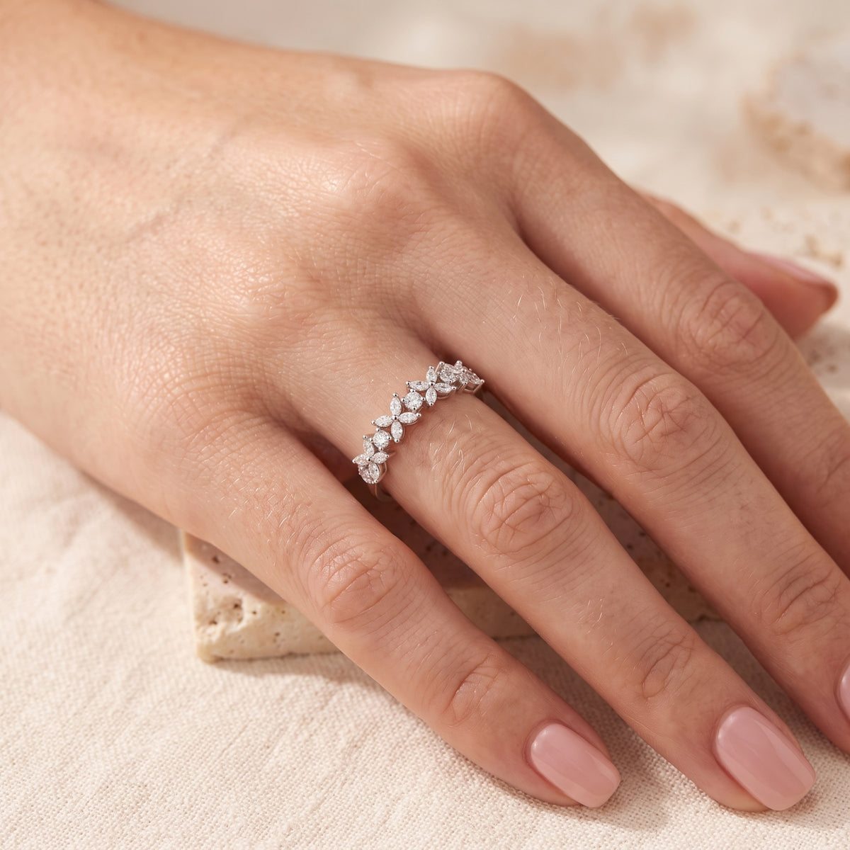 Silver floral cluster ring with marquise zircon stones shown on a model's finger.